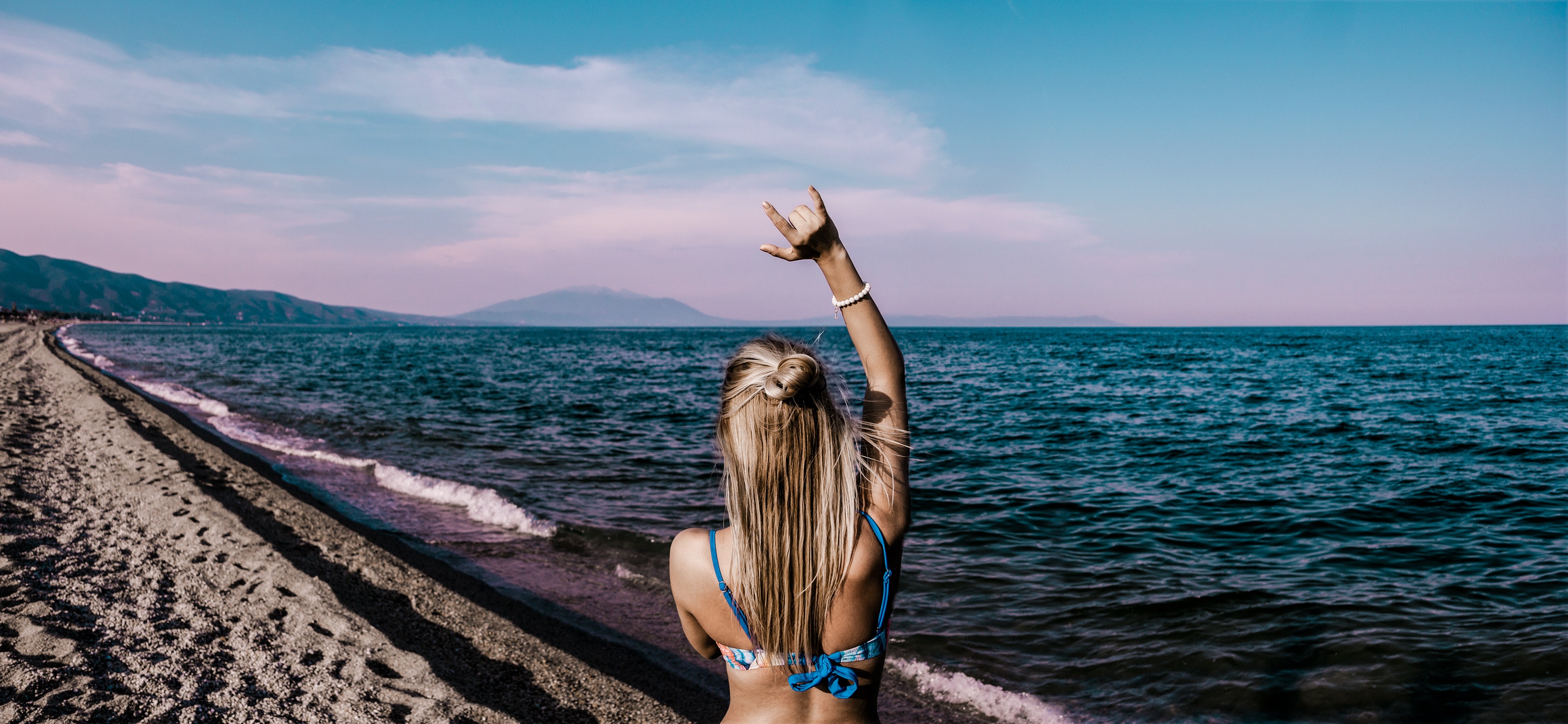 Woman in blue bikini standing beside shore photo