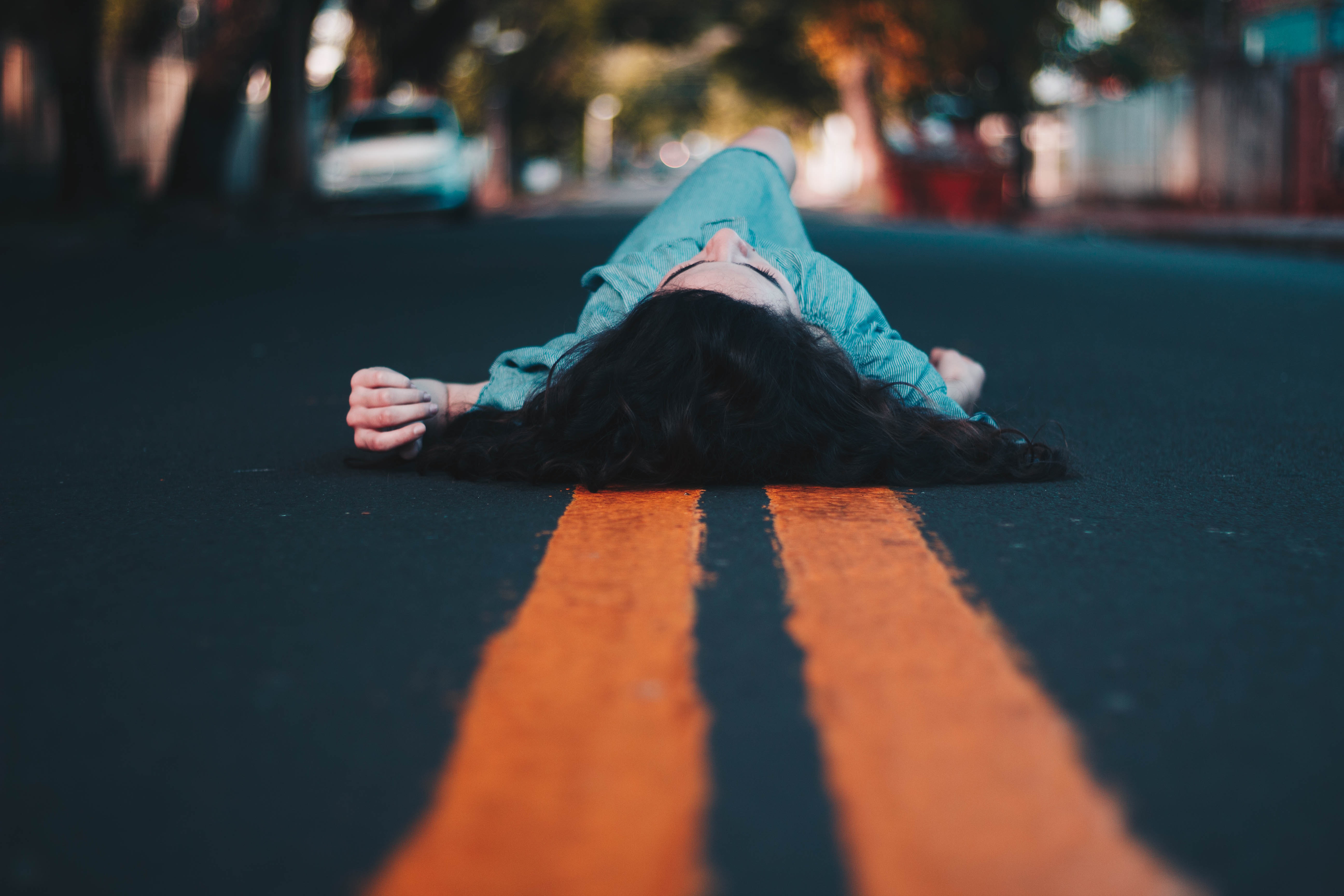 Woman in blue dress lying down on the street photo