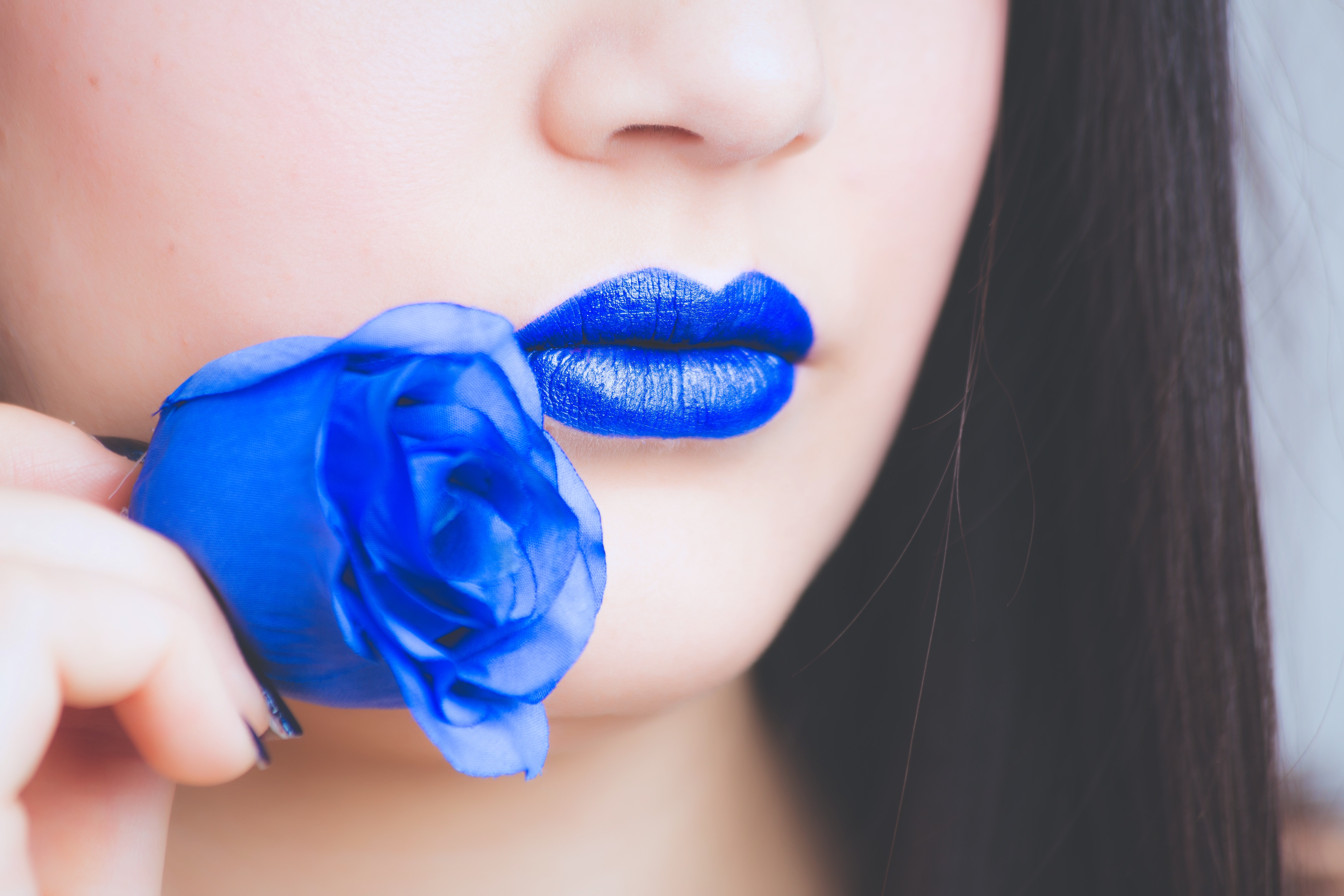 Woman in blue lipstick holding blue rose flower photo