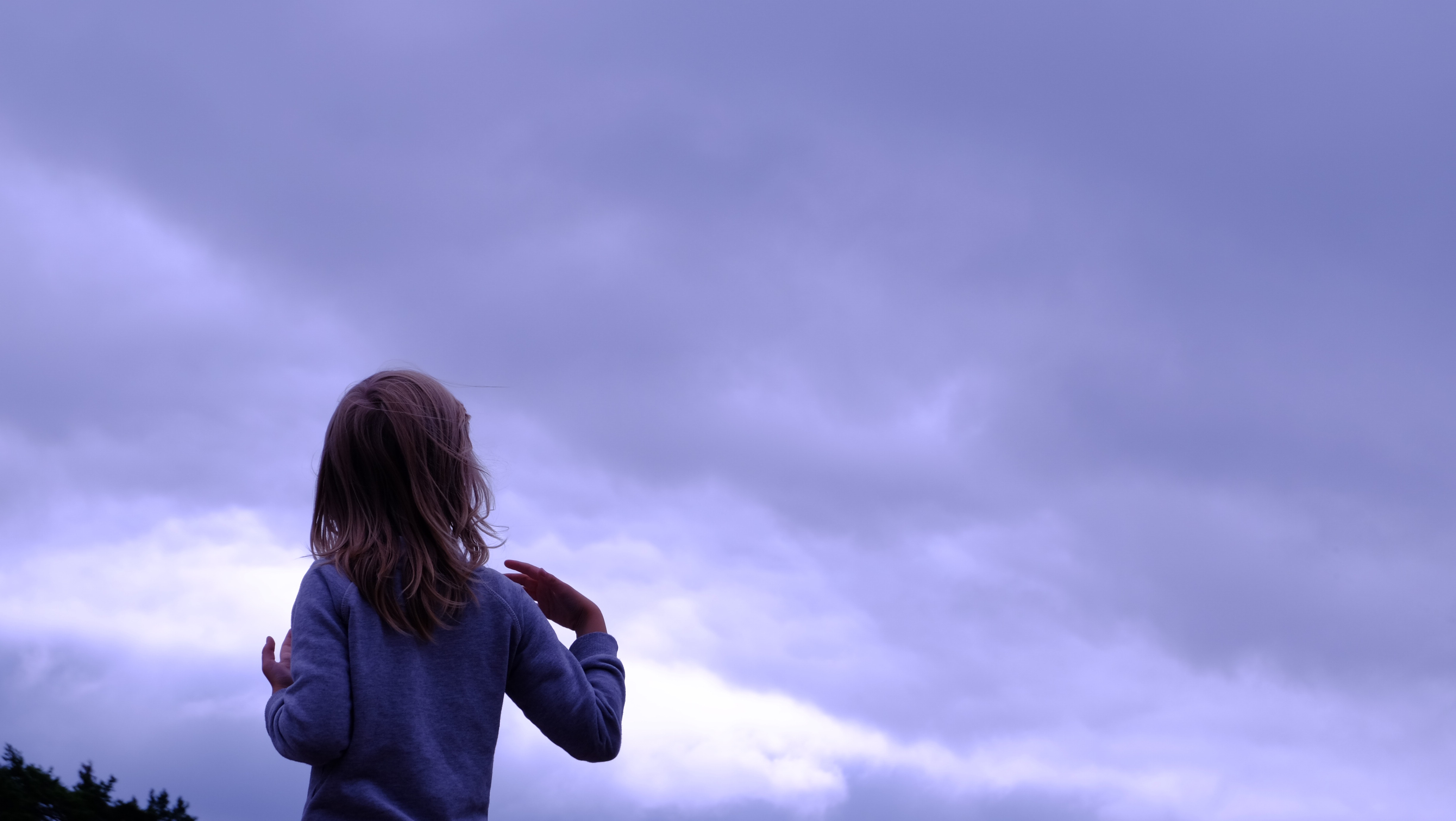 Woman in blue sweater facing in blue clear sky photo