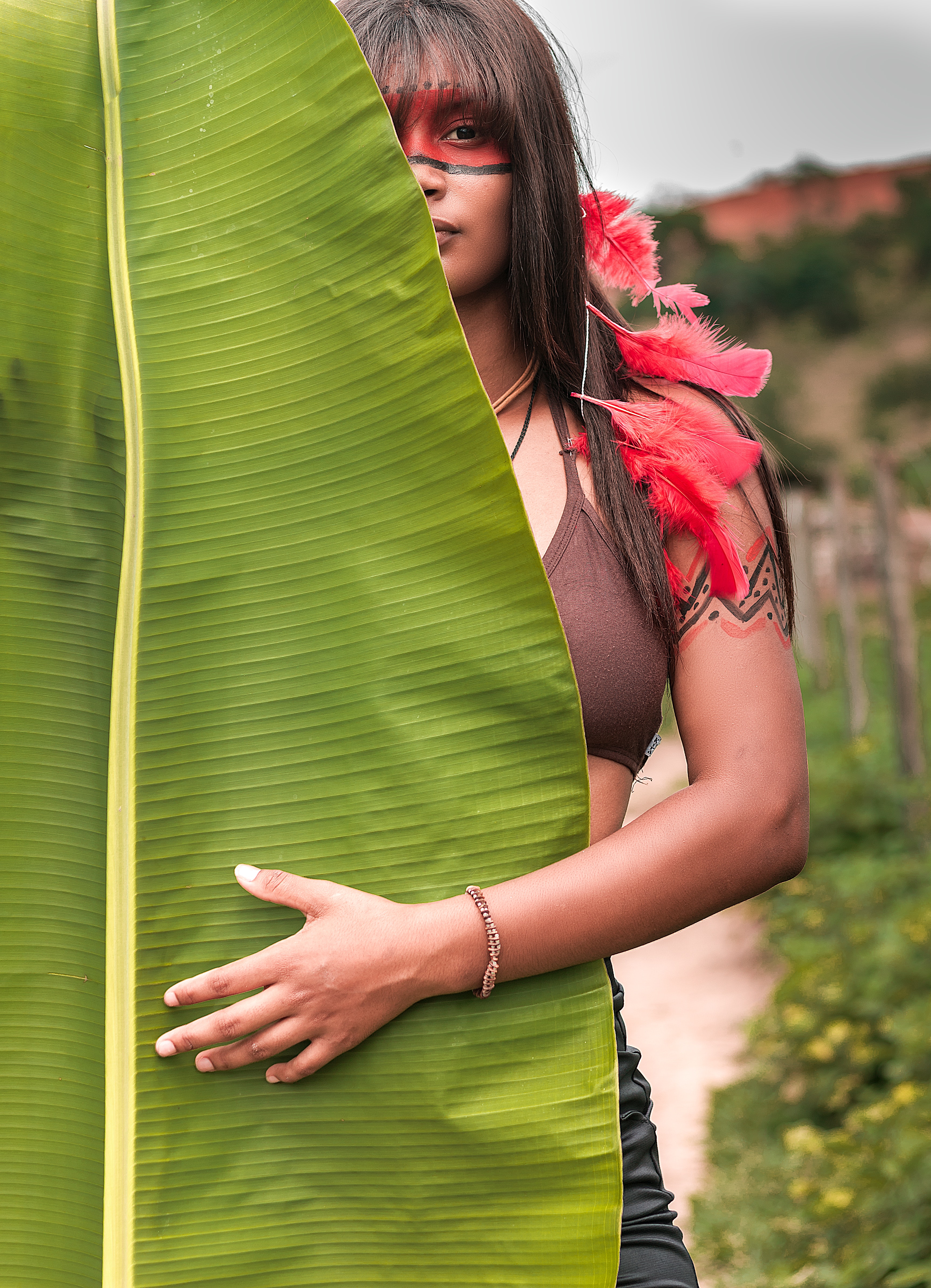 Woman in brown brassiere in front of banana leaf photo