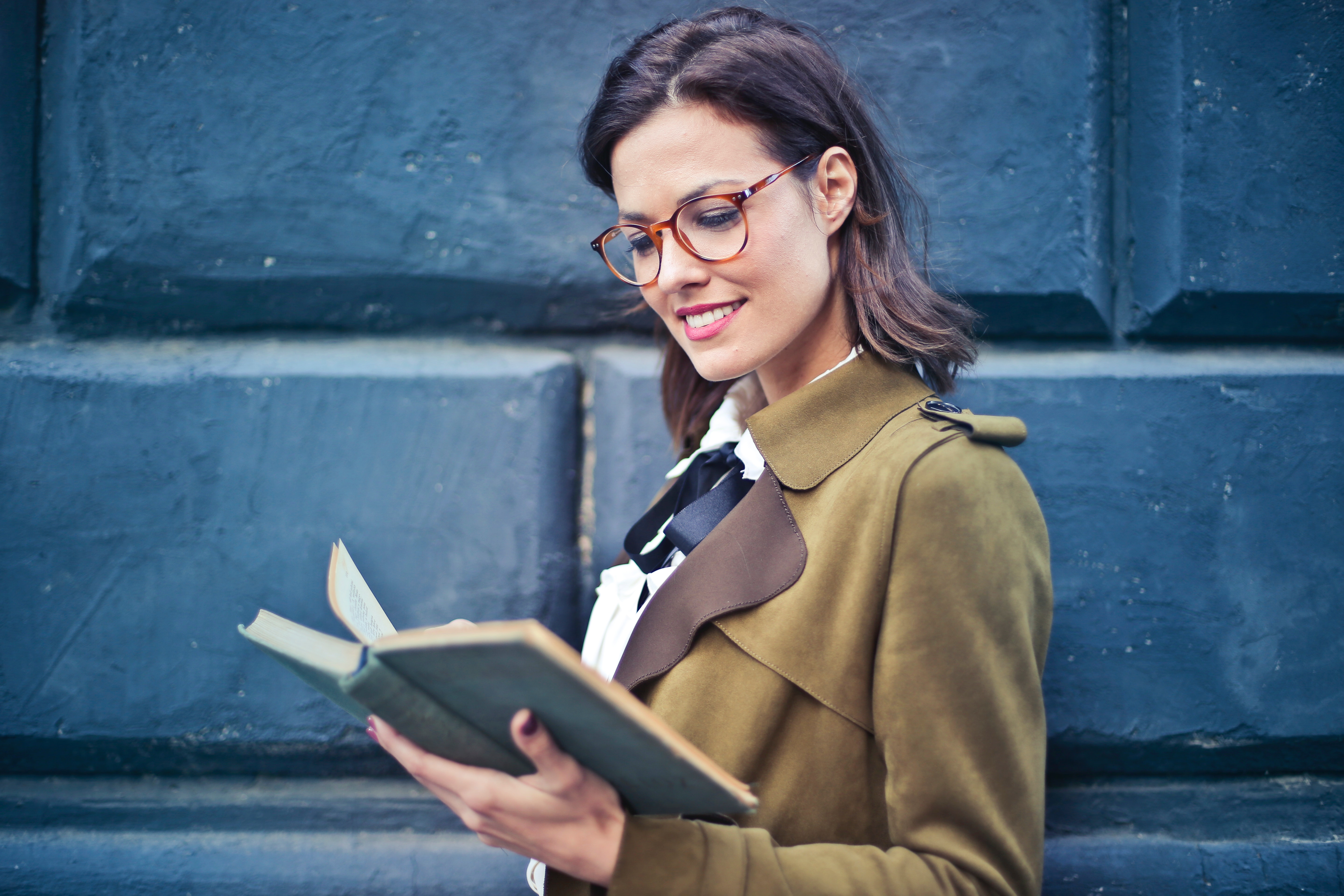 Woman in brown suede peacoat reading a book photo