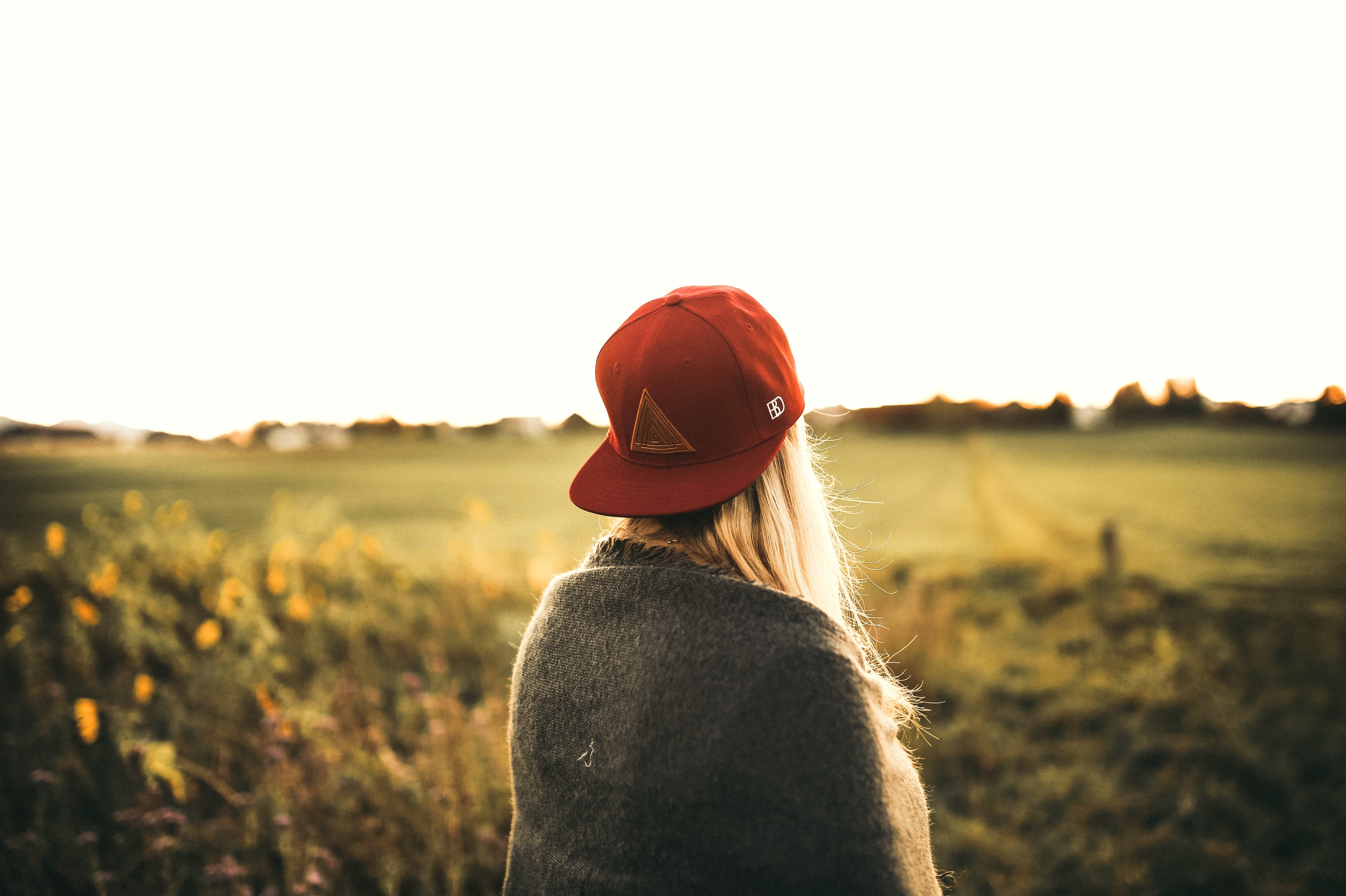 Woman in gray cardigan and red snapback cap photo