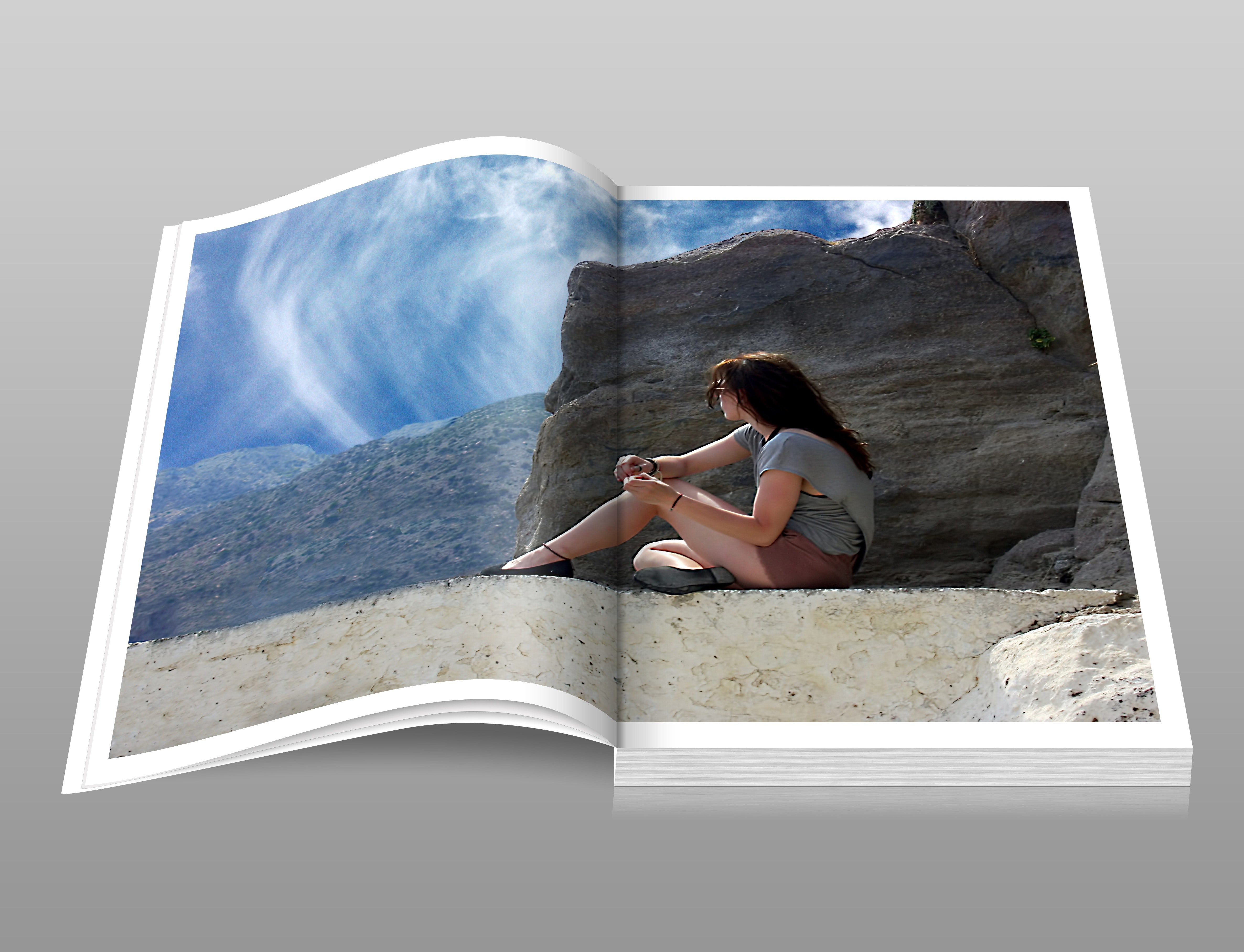 Woman in gray shirt sitting over brown formation of rock during daytime book photo