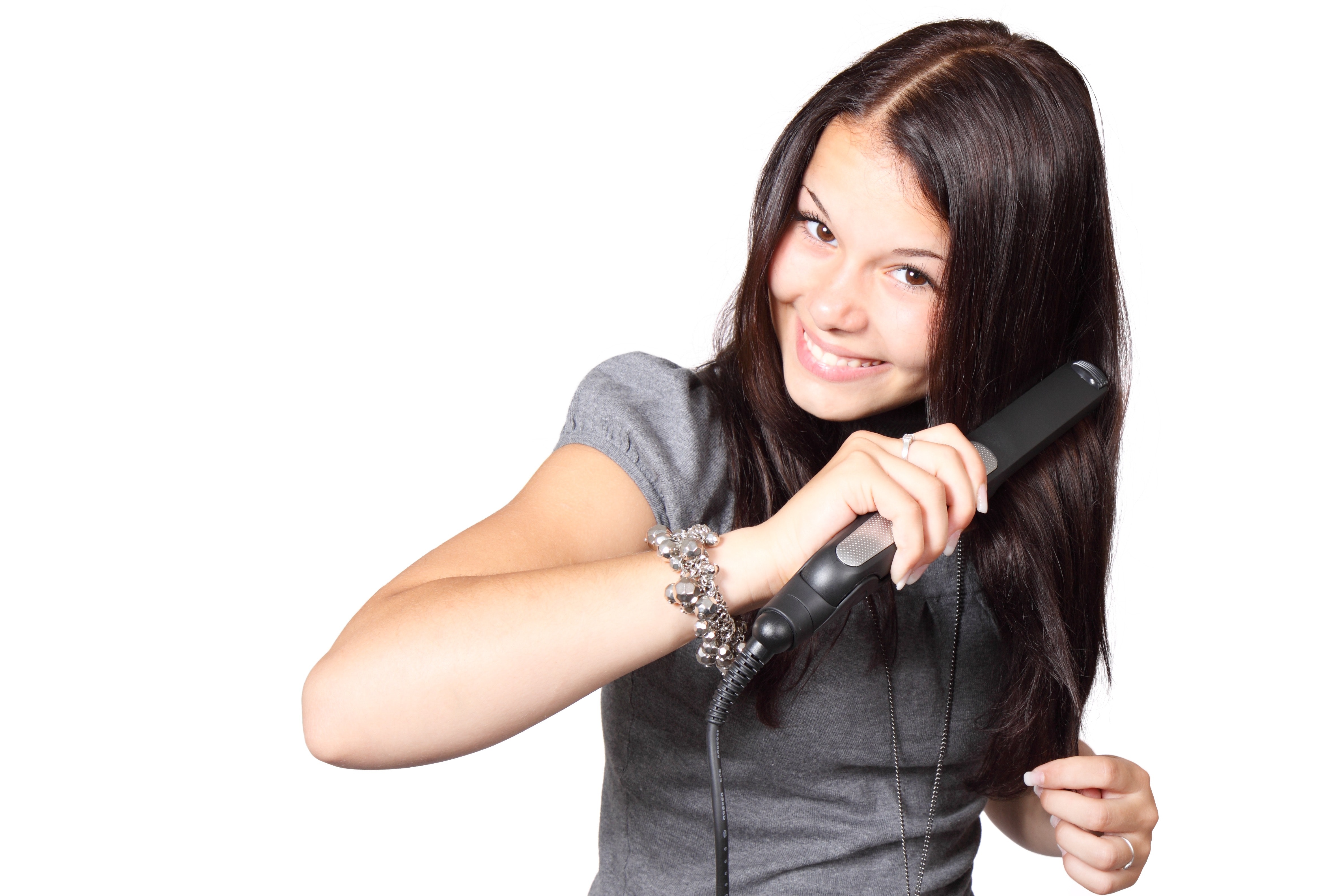 Woman in gray shirt straightening her hair photo