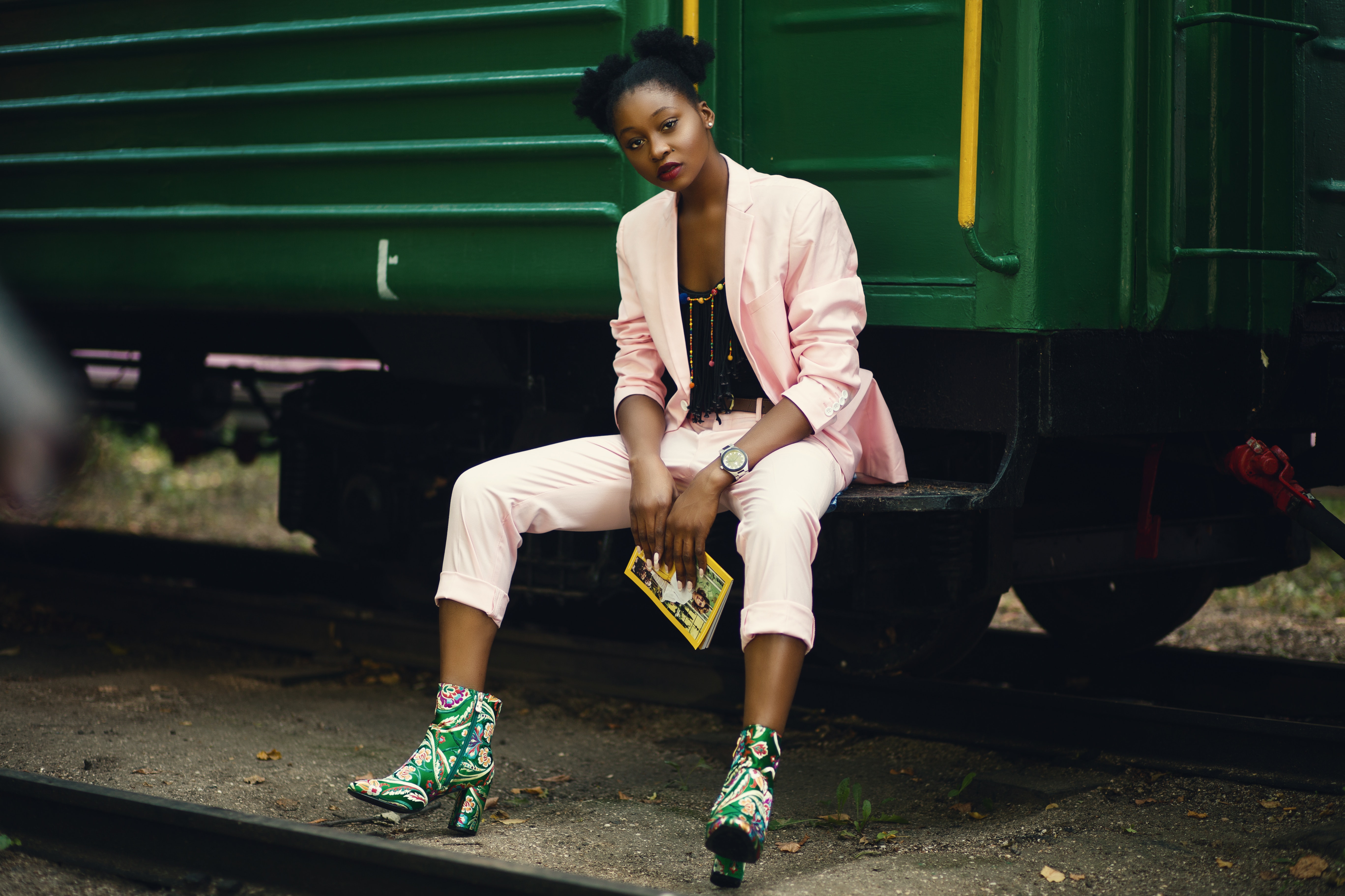 Woman in pink blazer sitting on green train photo