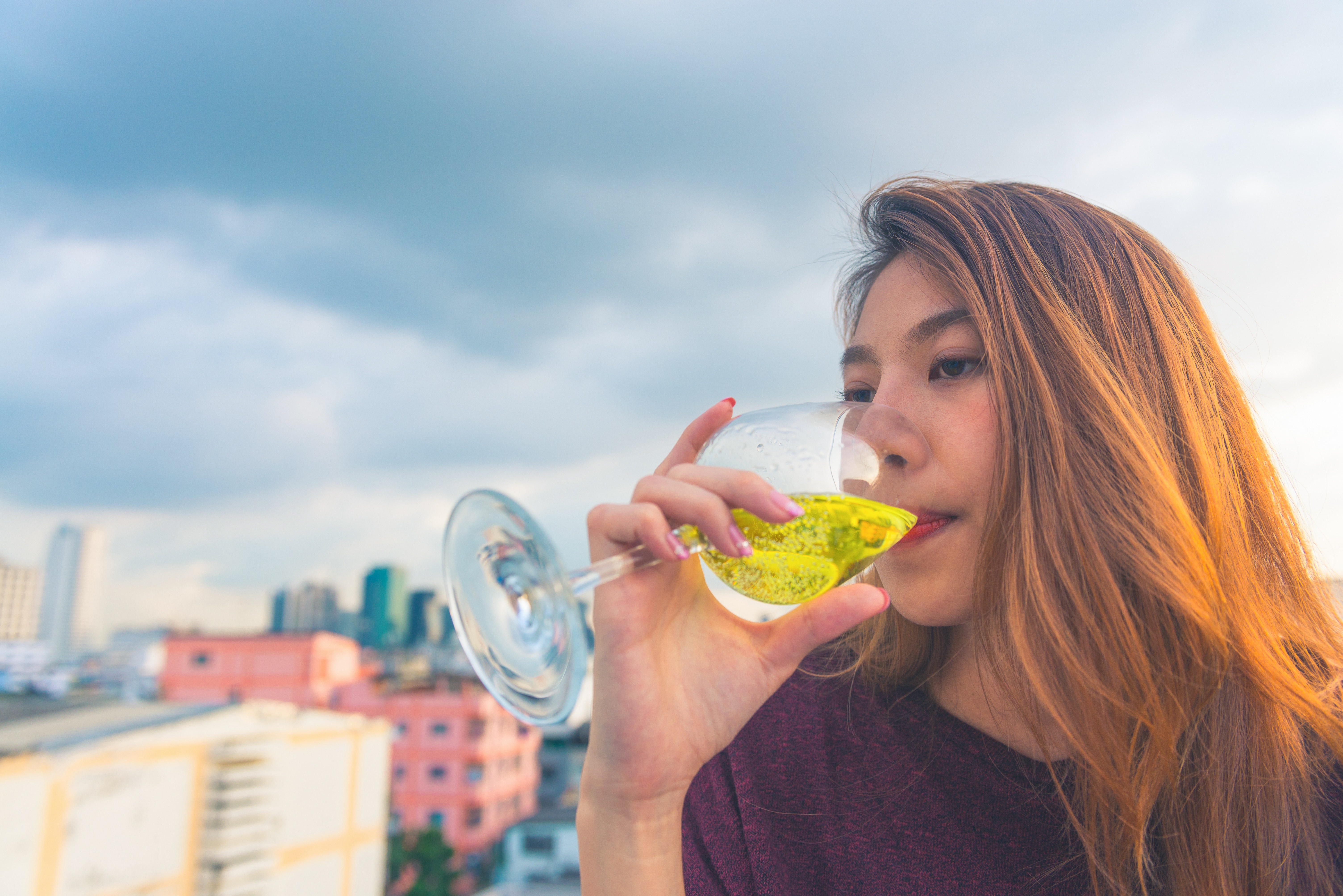 Woman in purple top drinking on clear wine glass photo