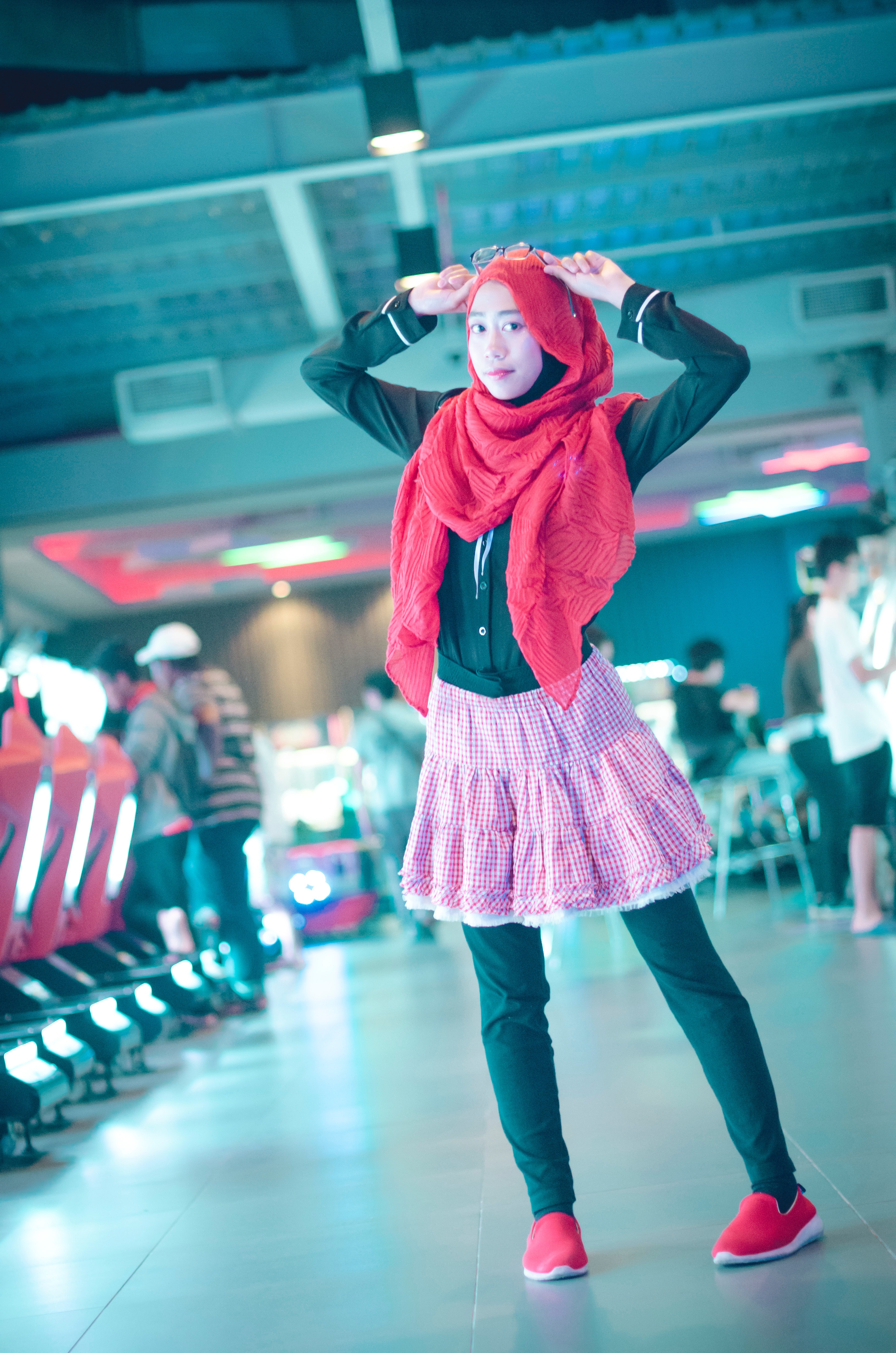 Woman in red head scarf with black dress shirt and pink skirt photo