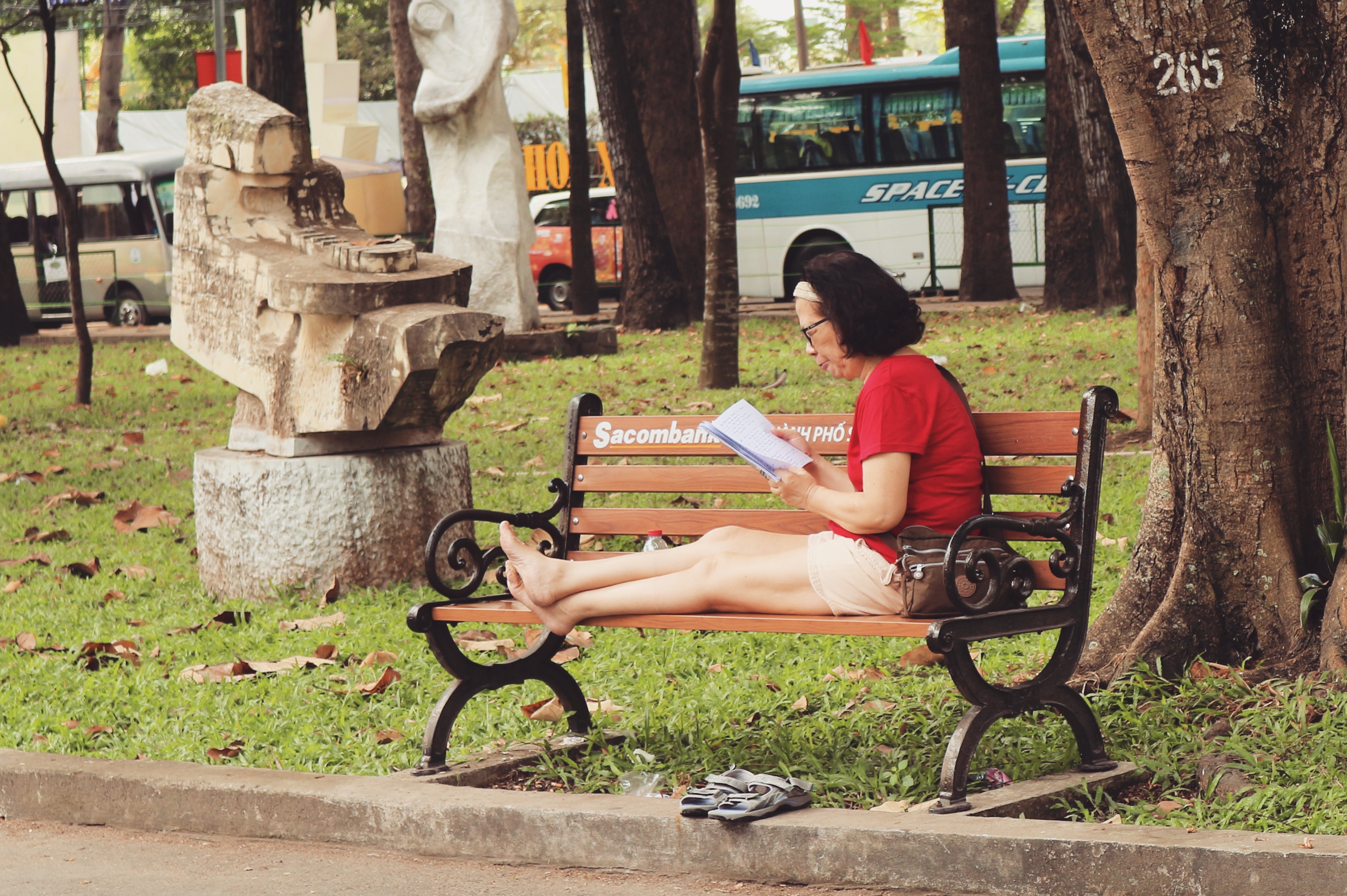 Woman in red shirt sitting on bench photo
