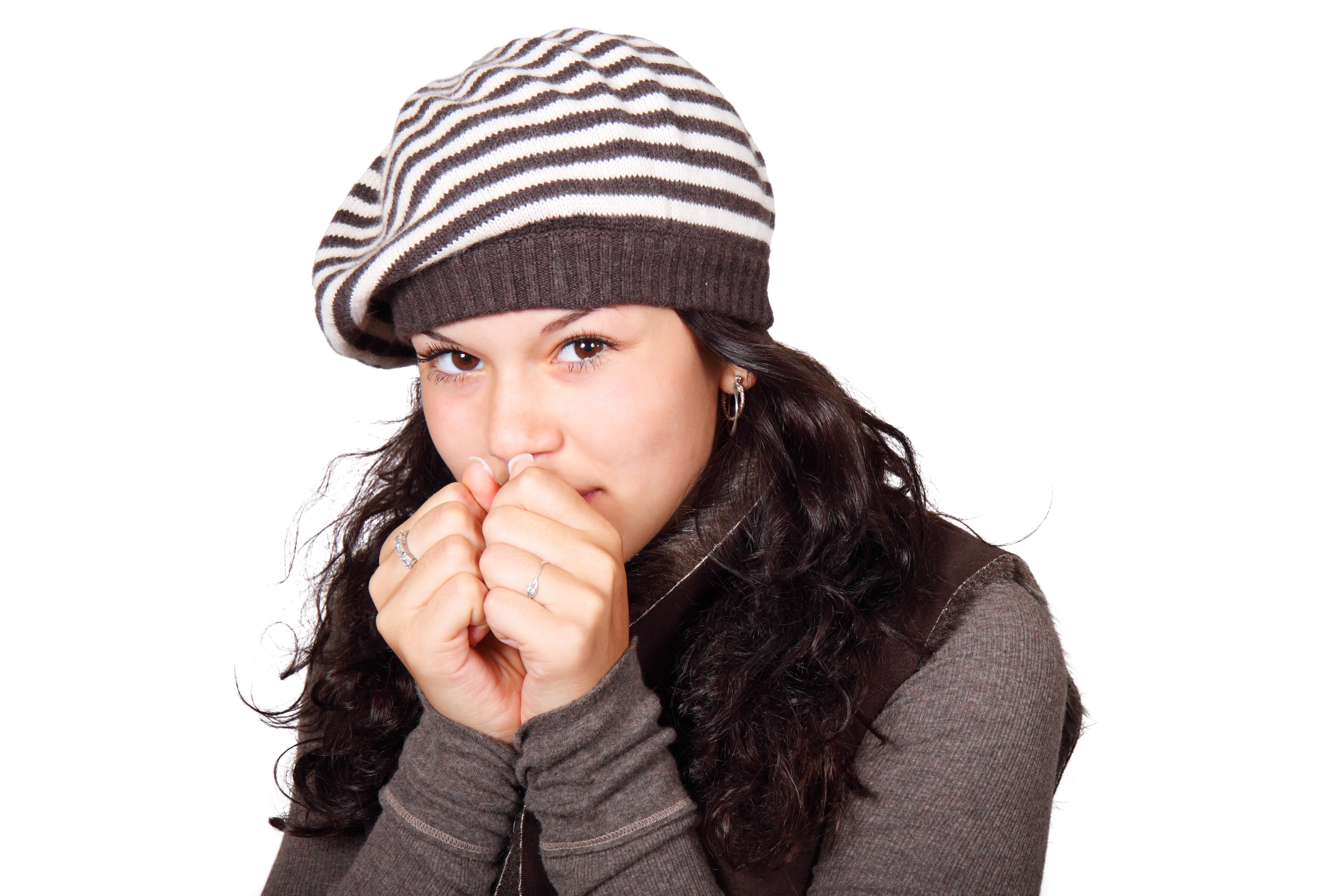 Woman in white and black stripe cap and grey shirt hands to face photo