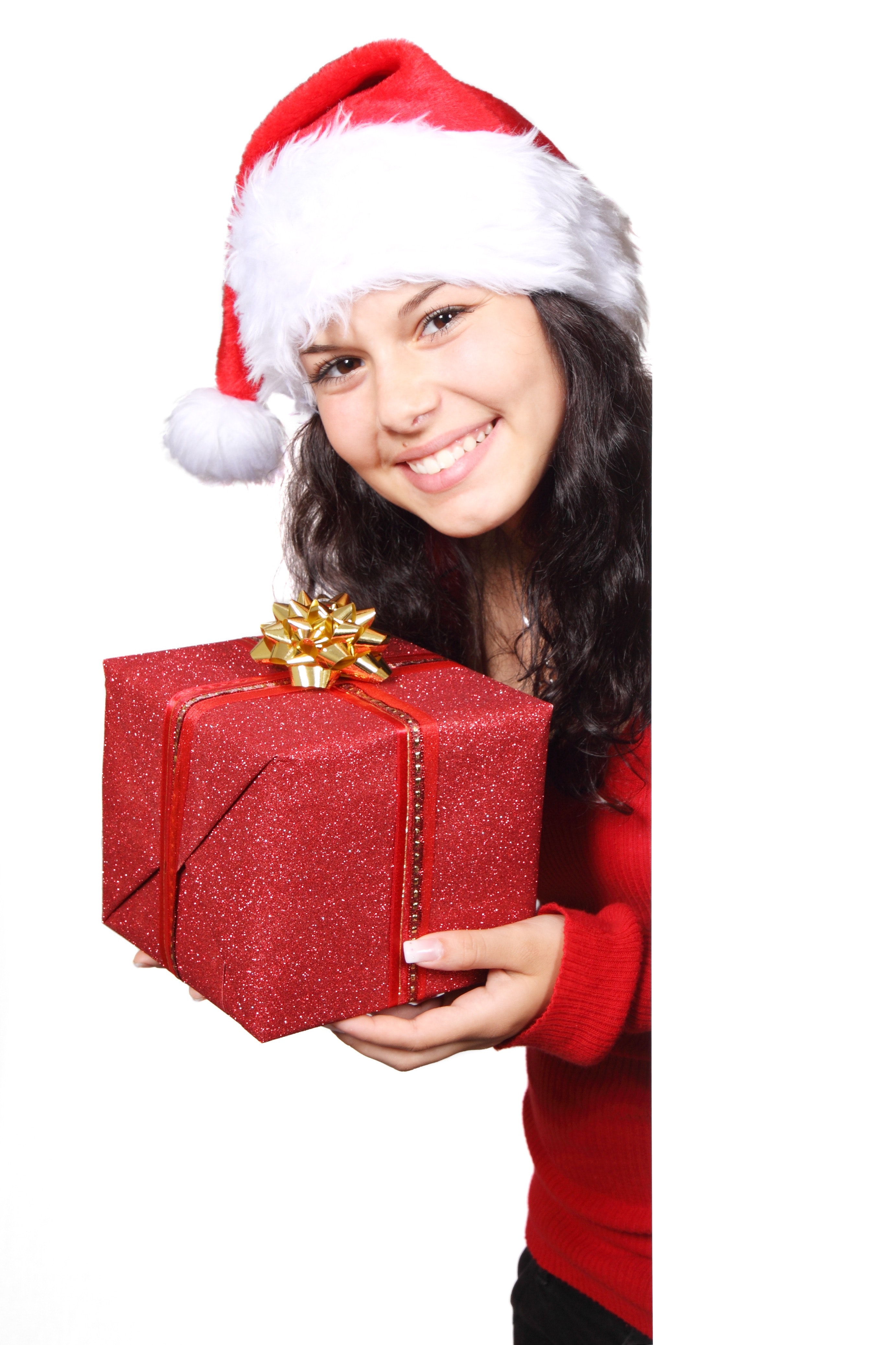 Woman in white and red santa hat holding red christmas gift photo