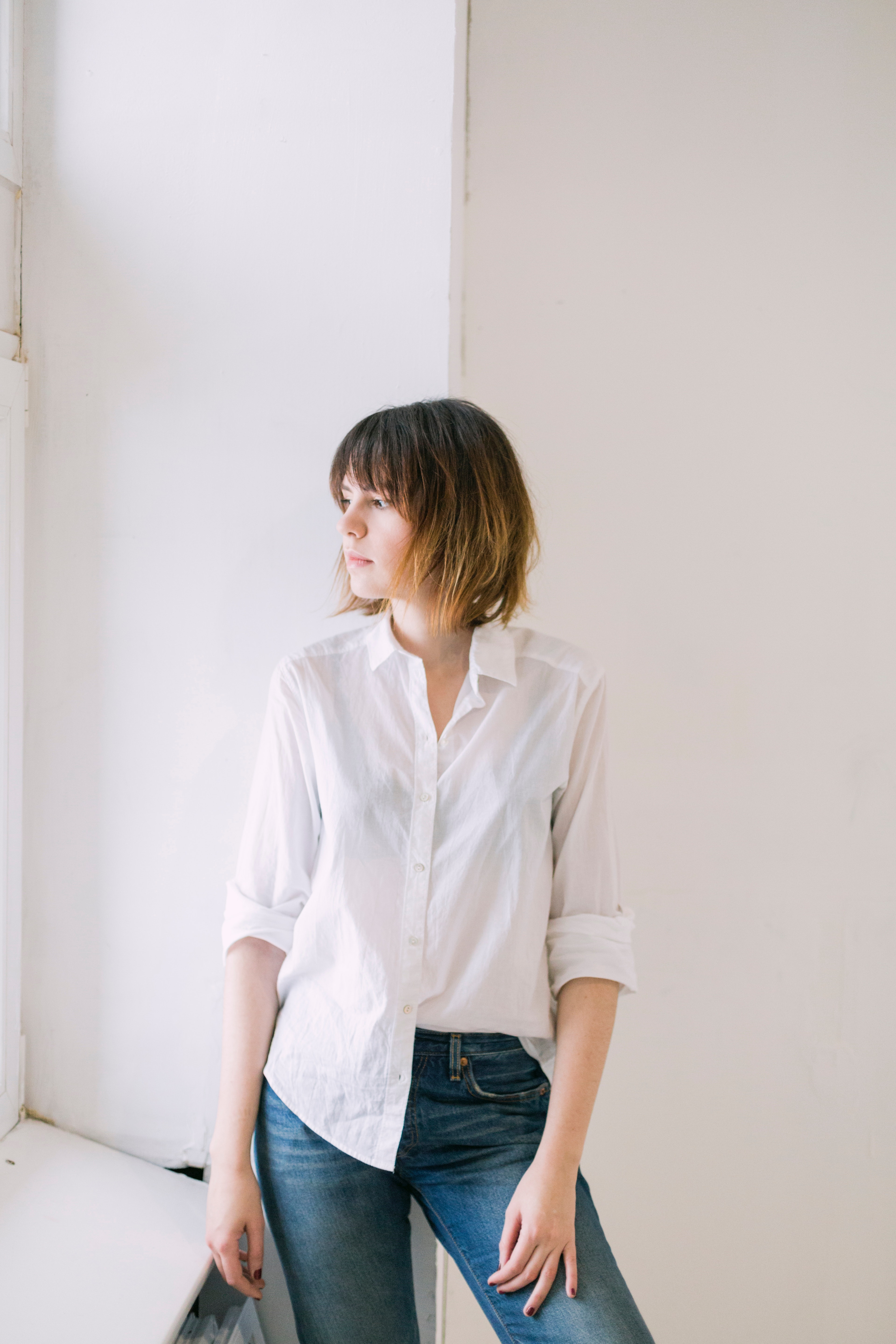Woman in white dress shirt and blue jeans photo
