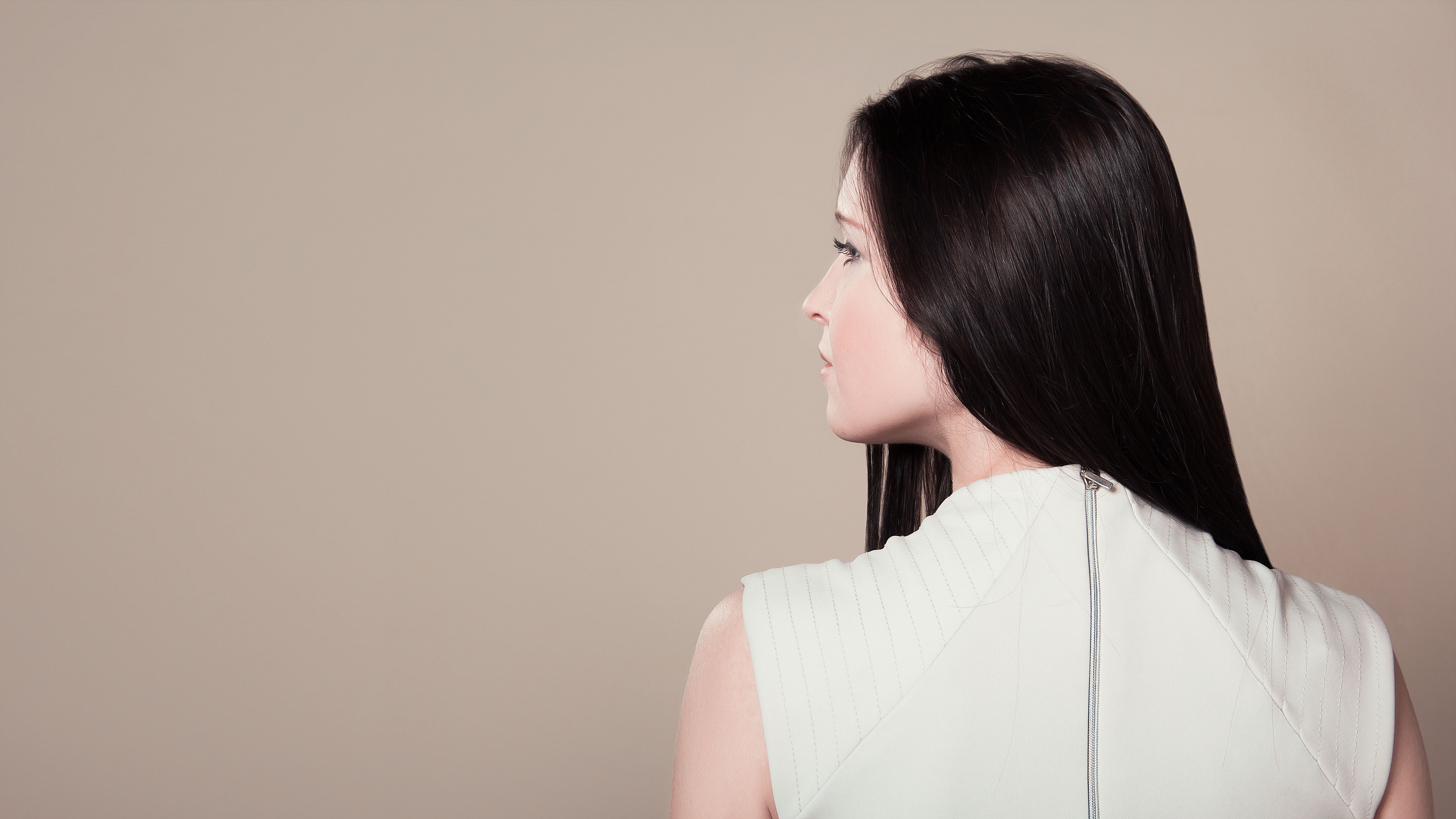 Woman in white sleeveless high neck top showing her back photo