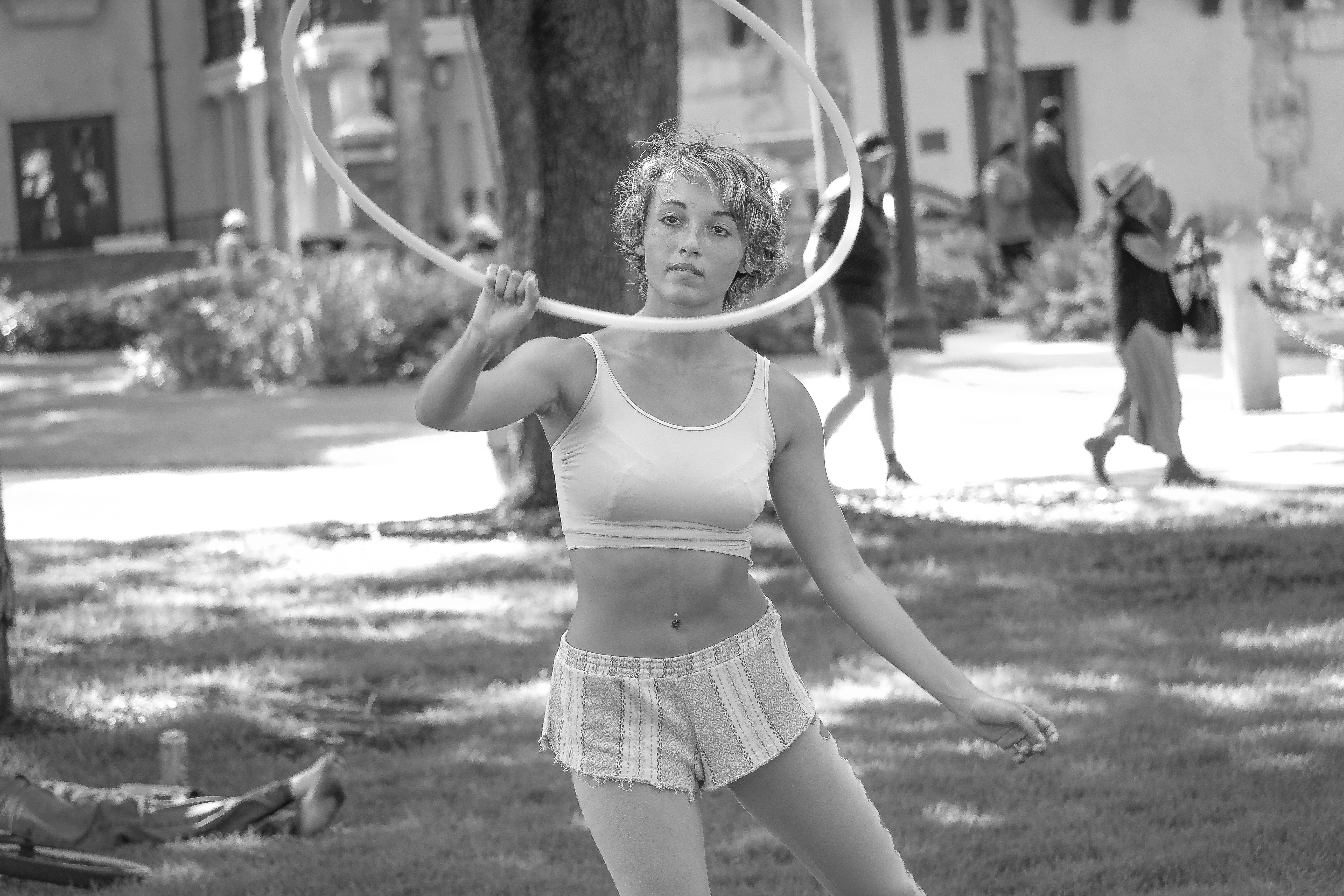 Woman in white sports bra and shorts holding hoop photo