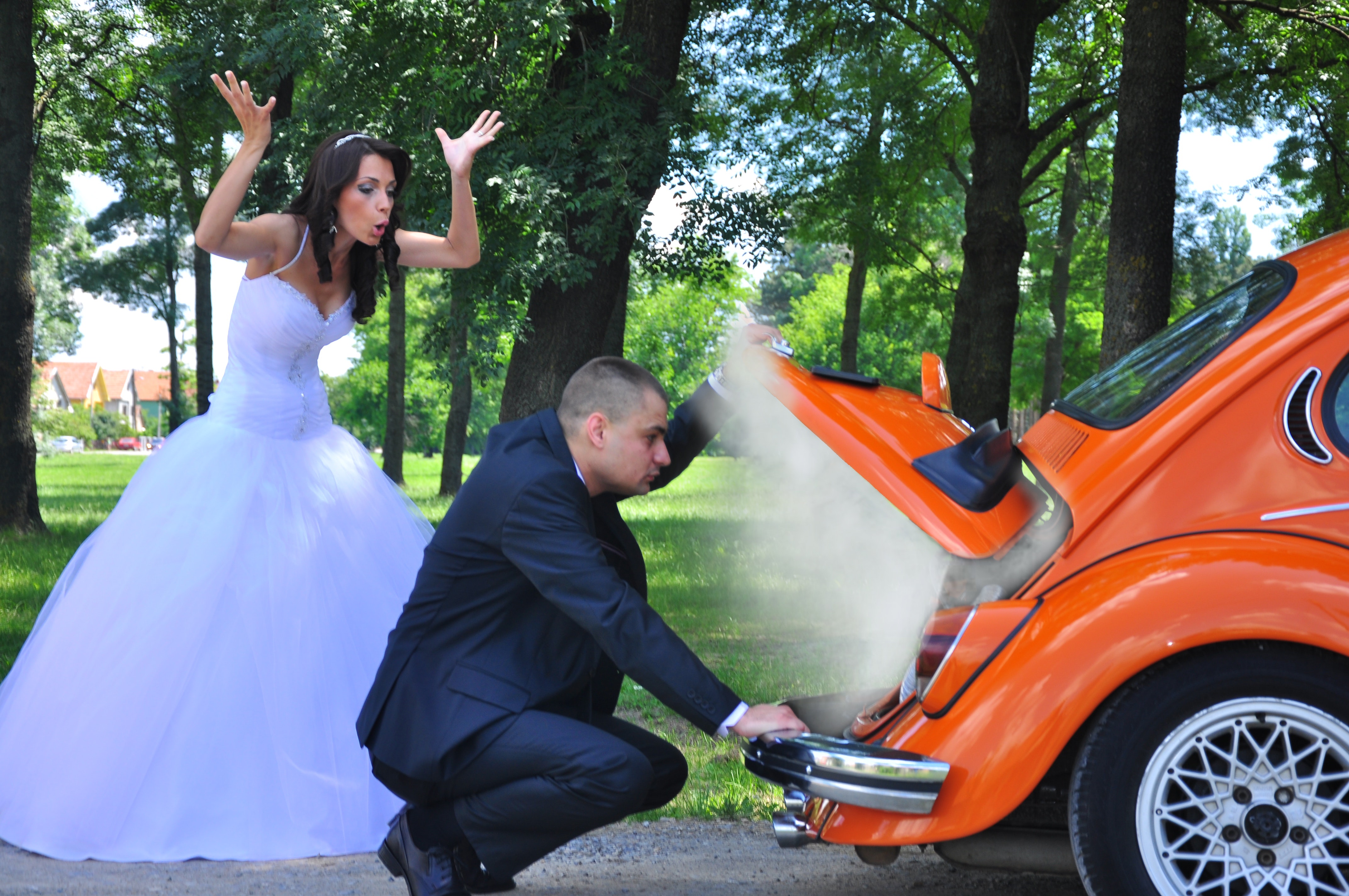 Woman in white wedding gown near orange car photo