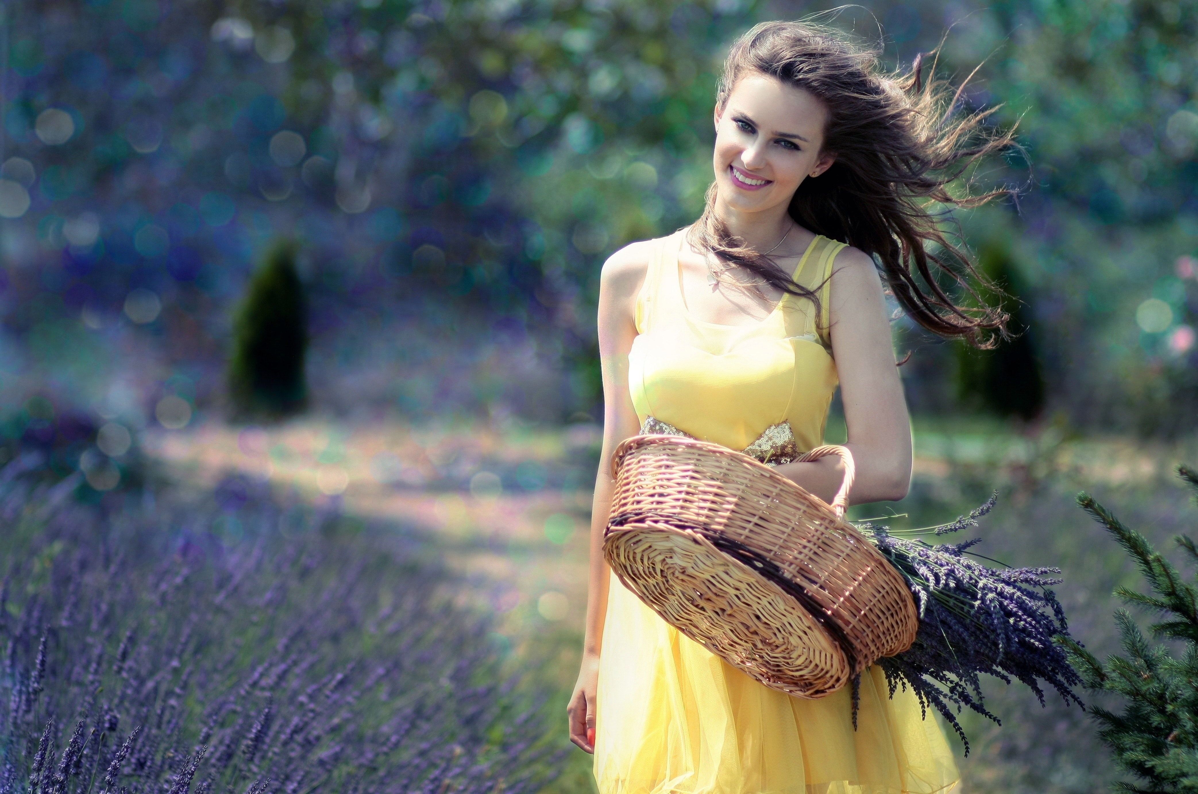 Woman in yellow maxi dress holding brown woven picnic basket walking during daytime photo
