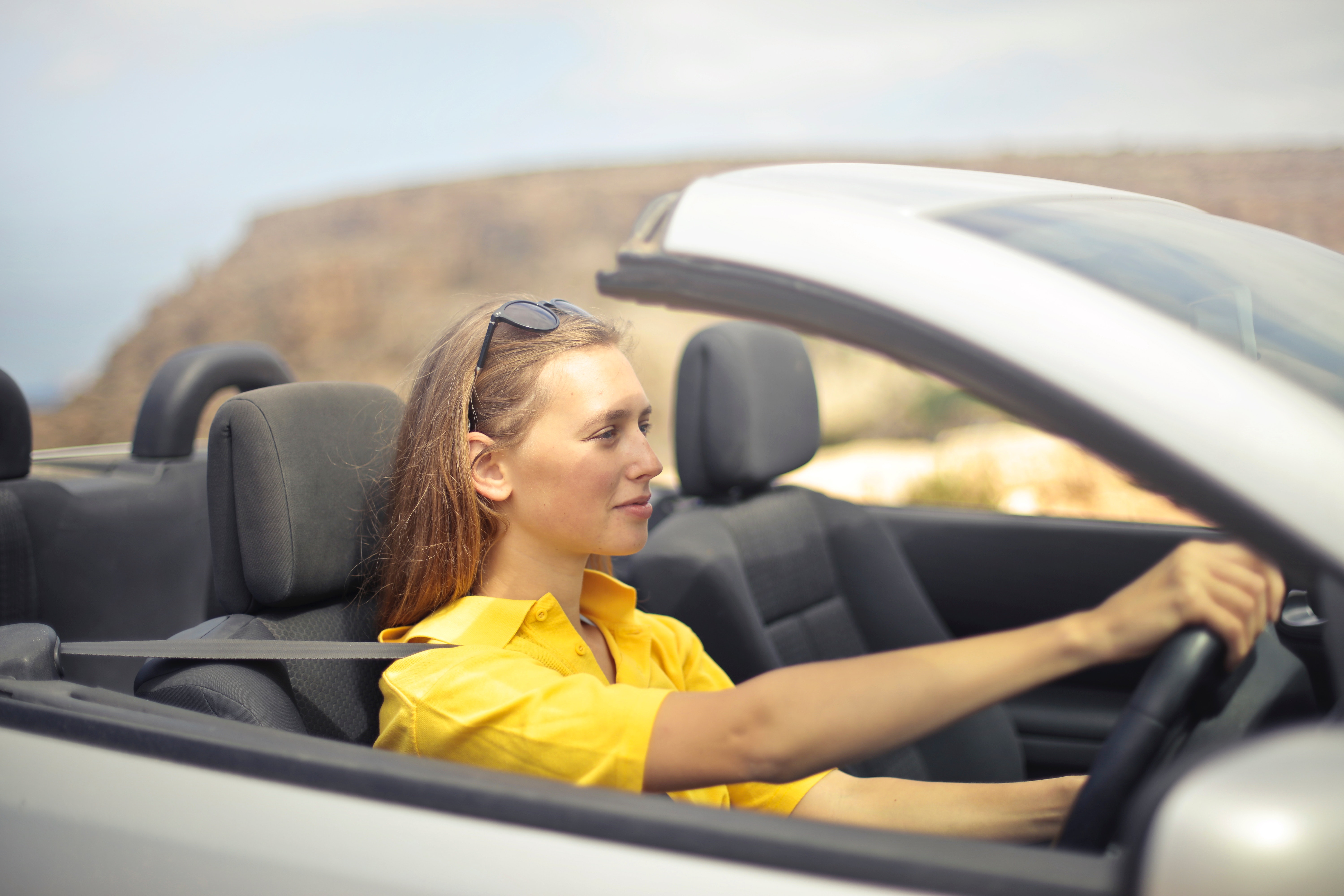 Woman in yellow shirt driving a silver car photo