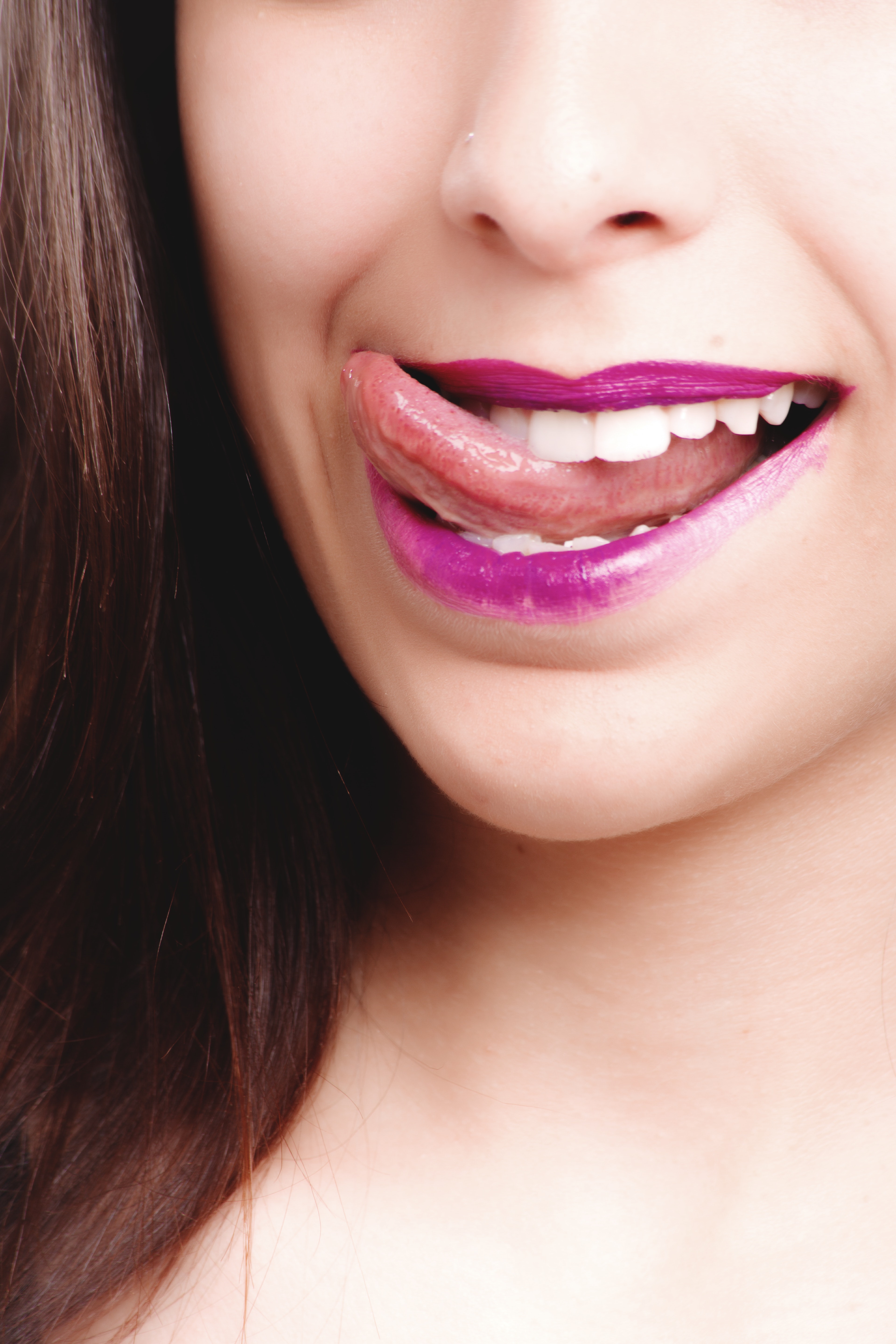 Woman licking with purple lips photo