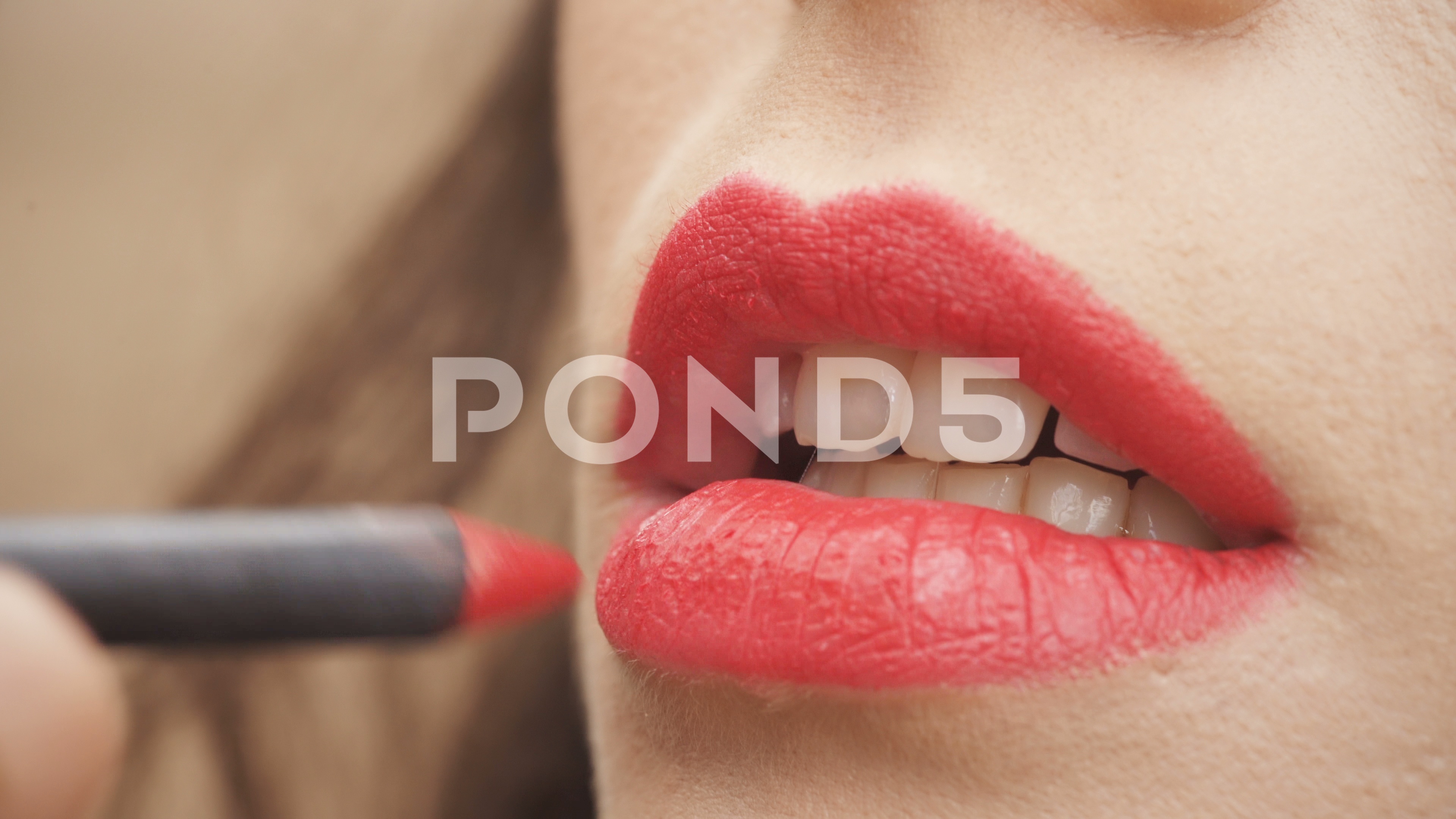 Video: Applying red lipstick with pencil on woman's lips ~ #83313119
