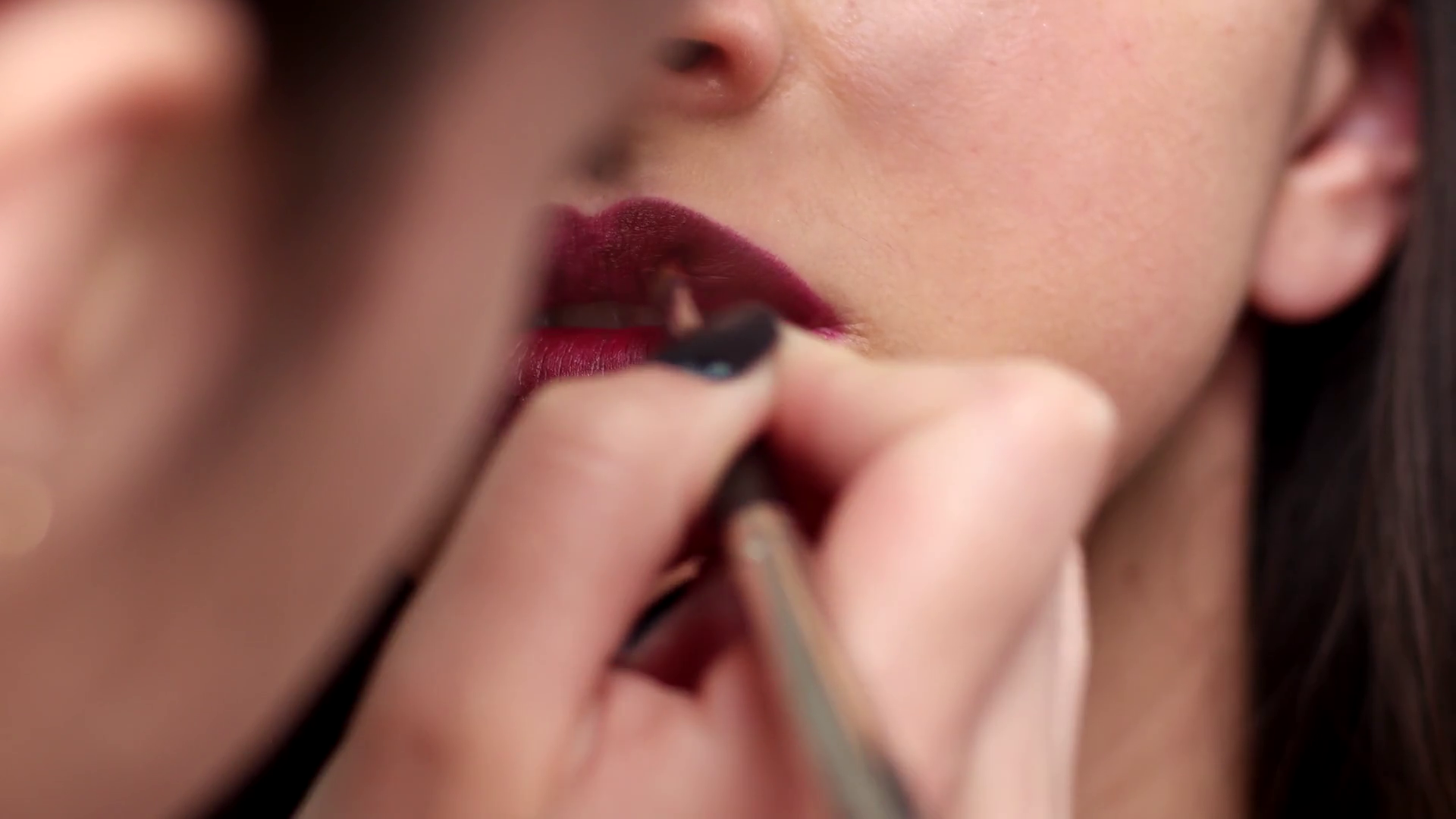 beautiful girl lips close-up, make-up artist applies lipstick brush ...