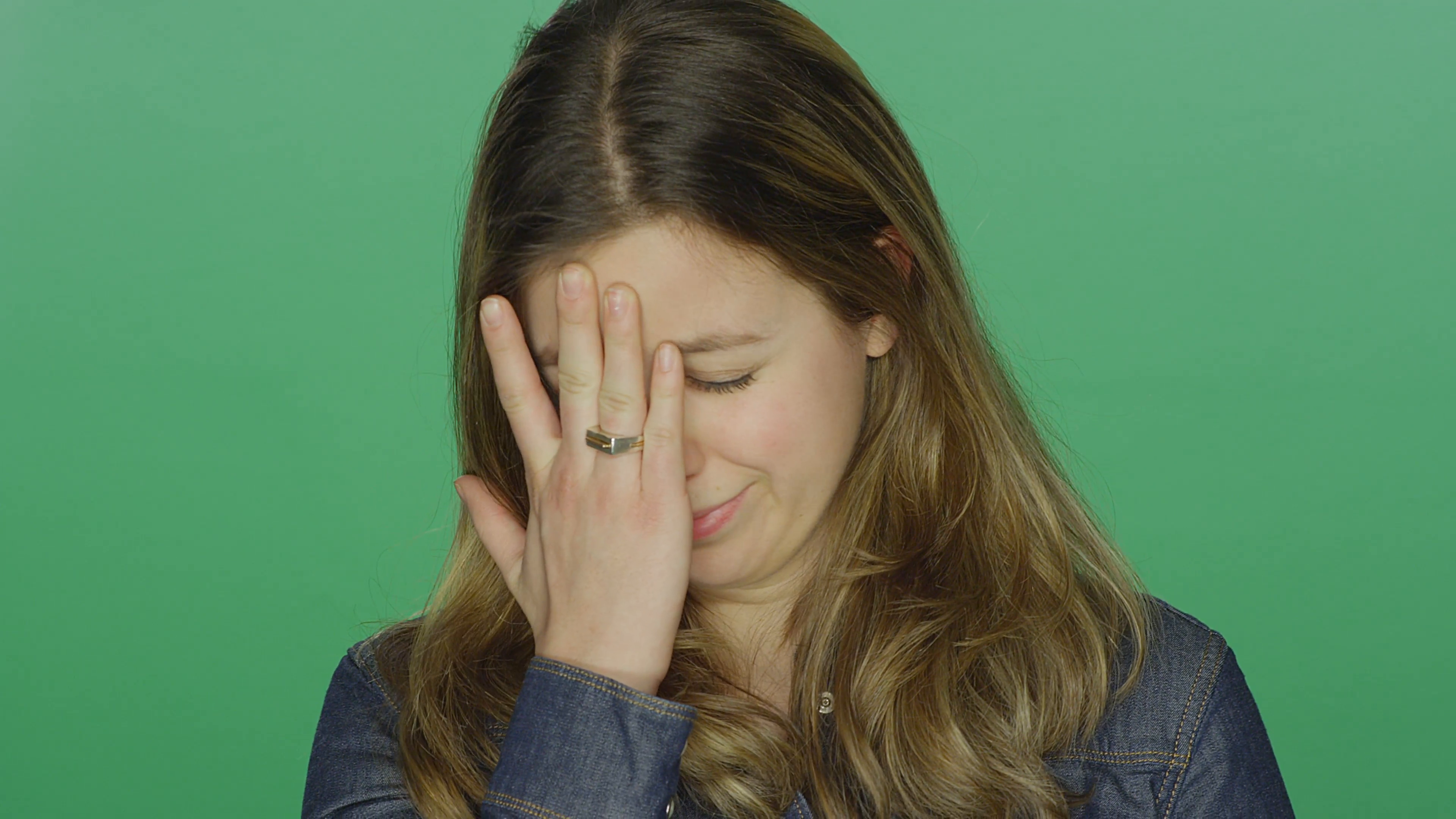 Young woman looking sad and starting to cry, on a green screen ...
