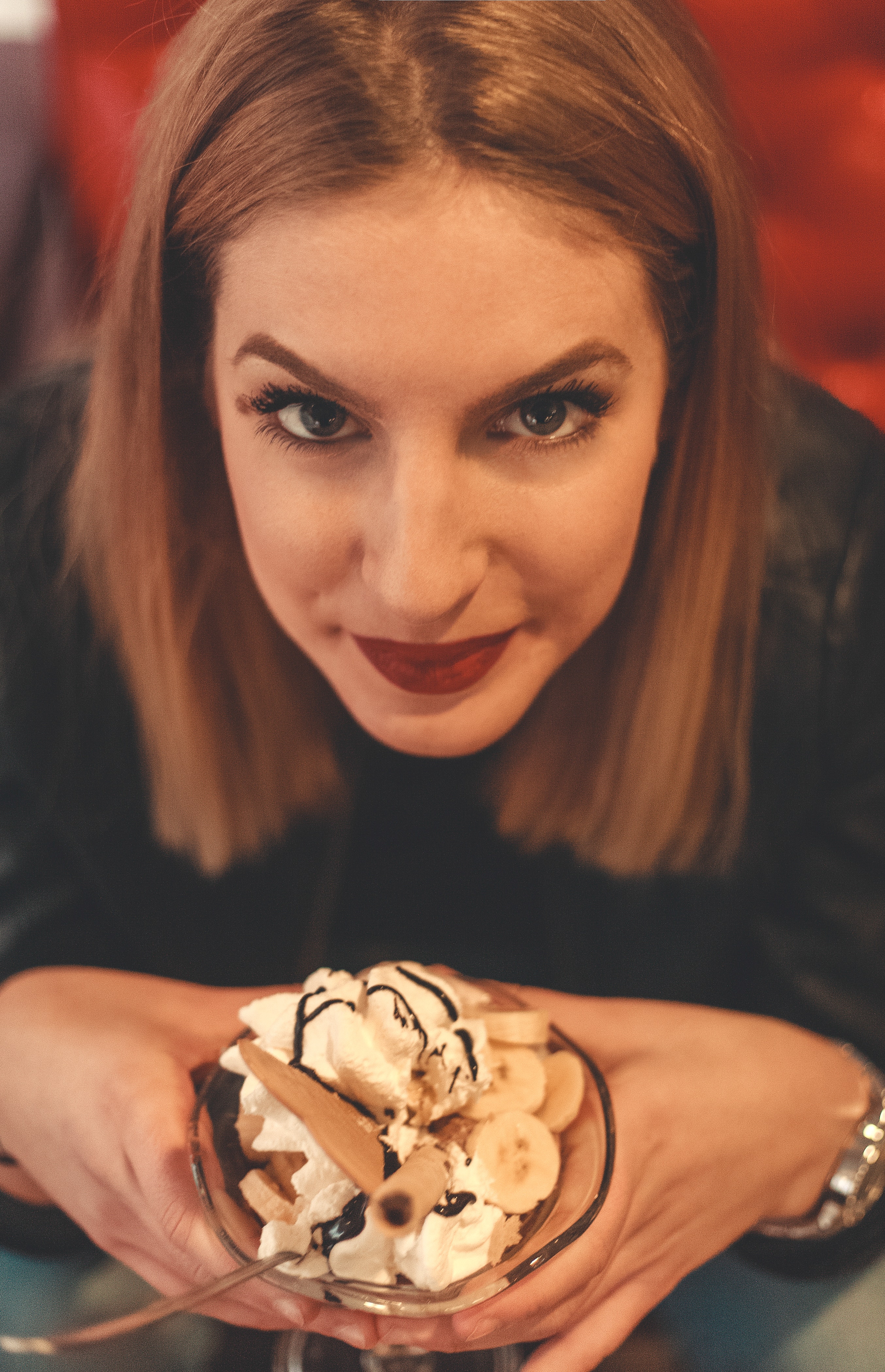 Woman looking on camera holding bowl with ice cream photo