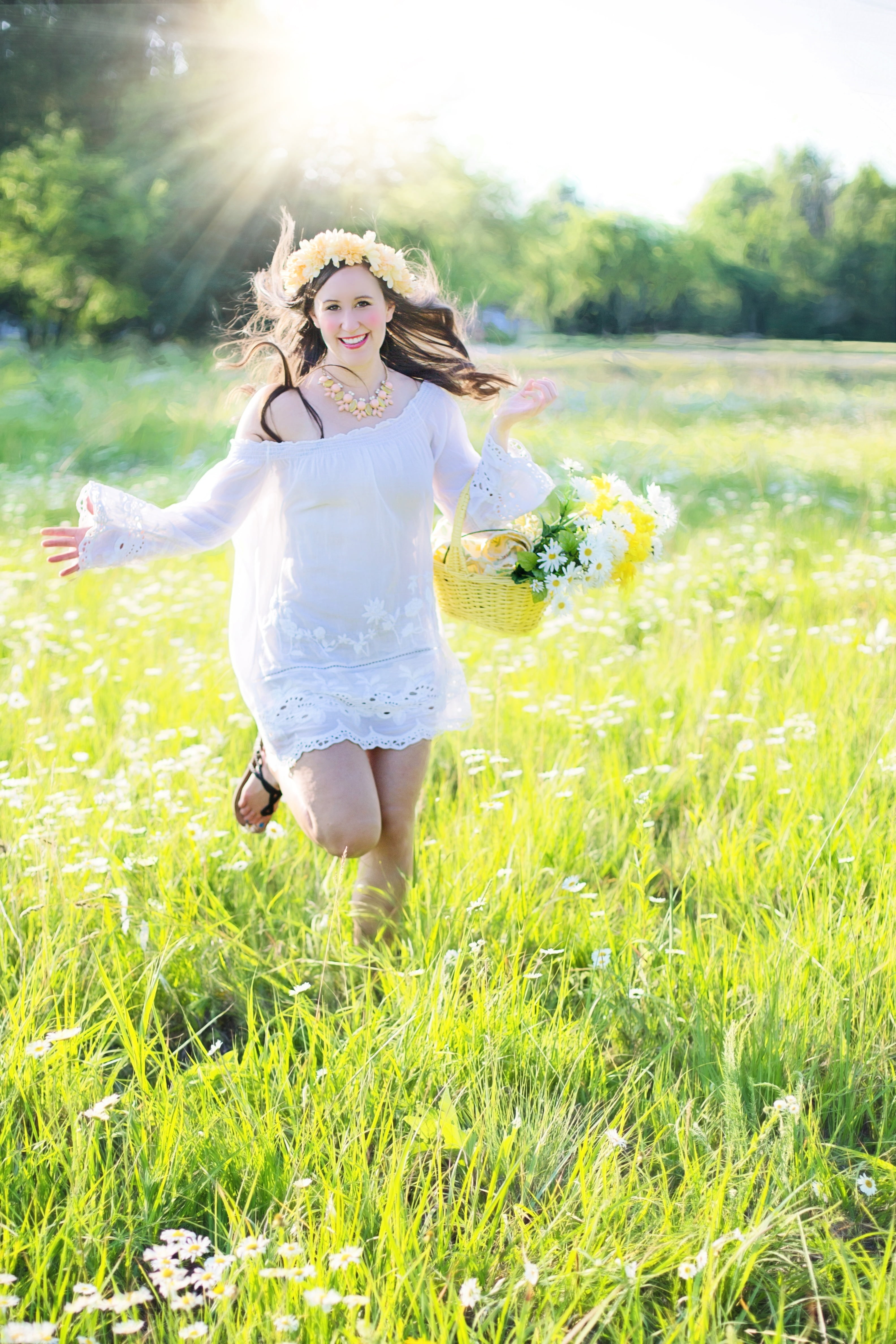 Woman running through green grass field holding a flower basket ...