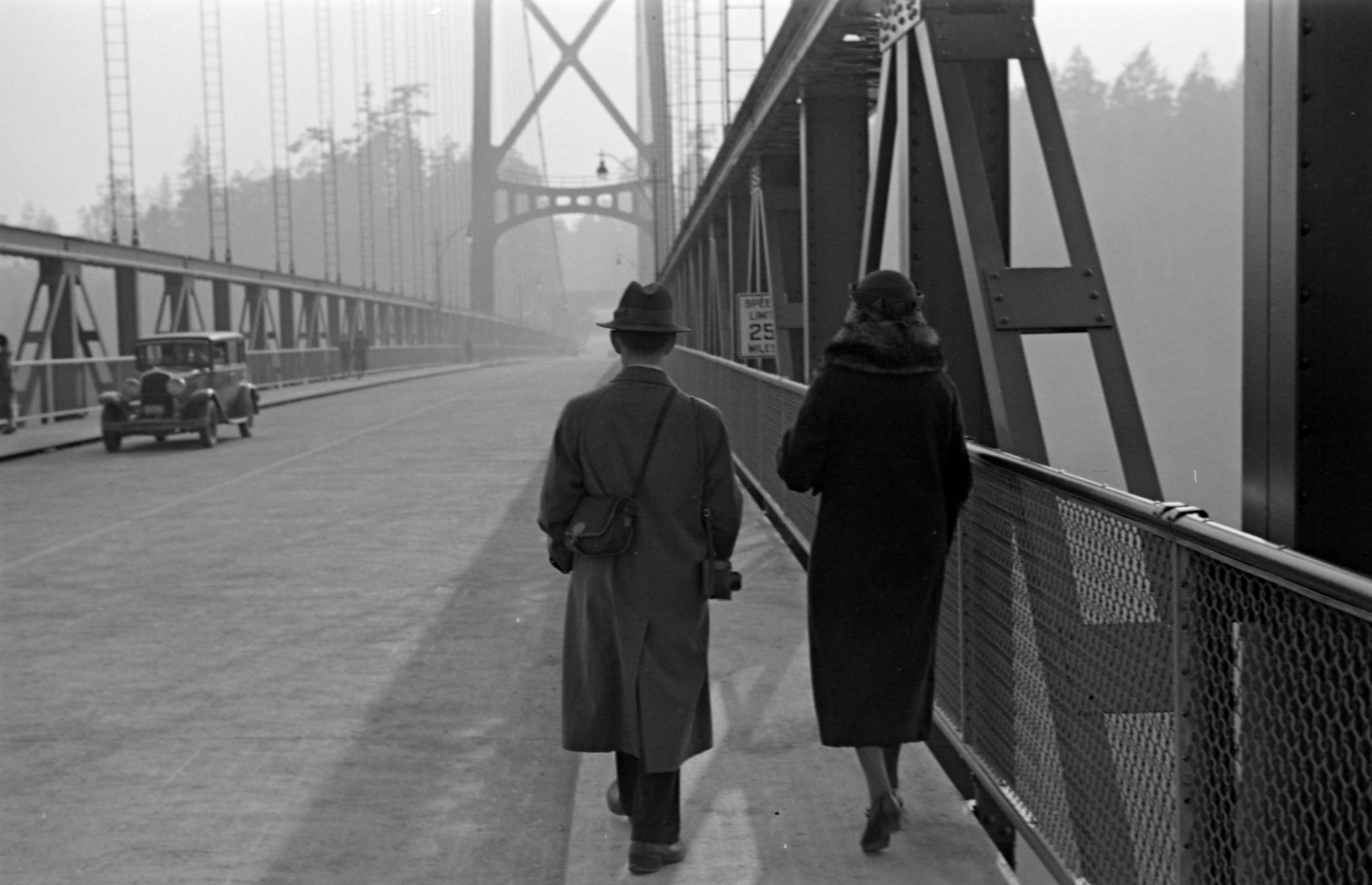 A man and woman walking across the Lions Gate Bridge] - City of ...