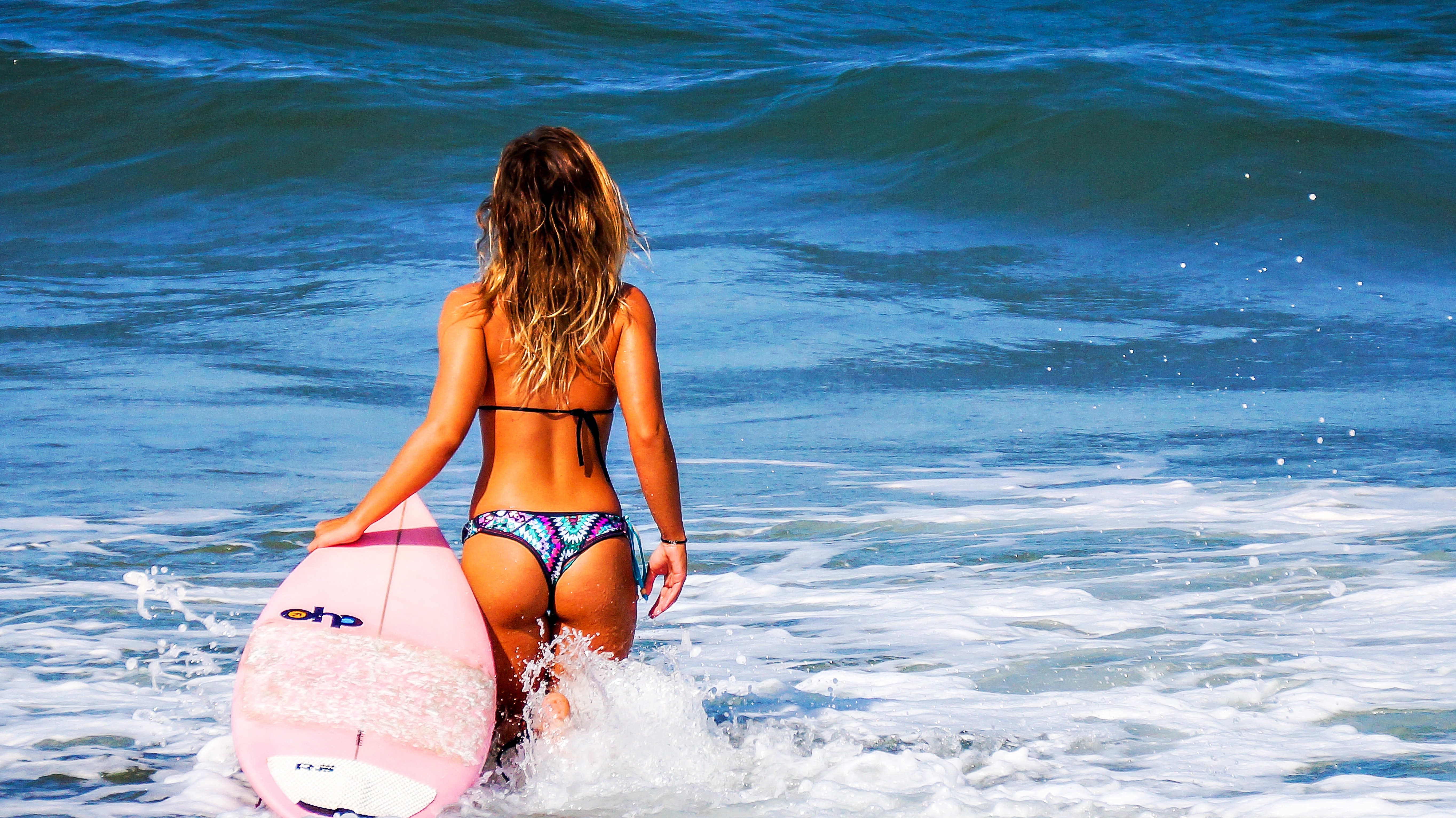 Woman on large body of water during daytime holding surf board photo