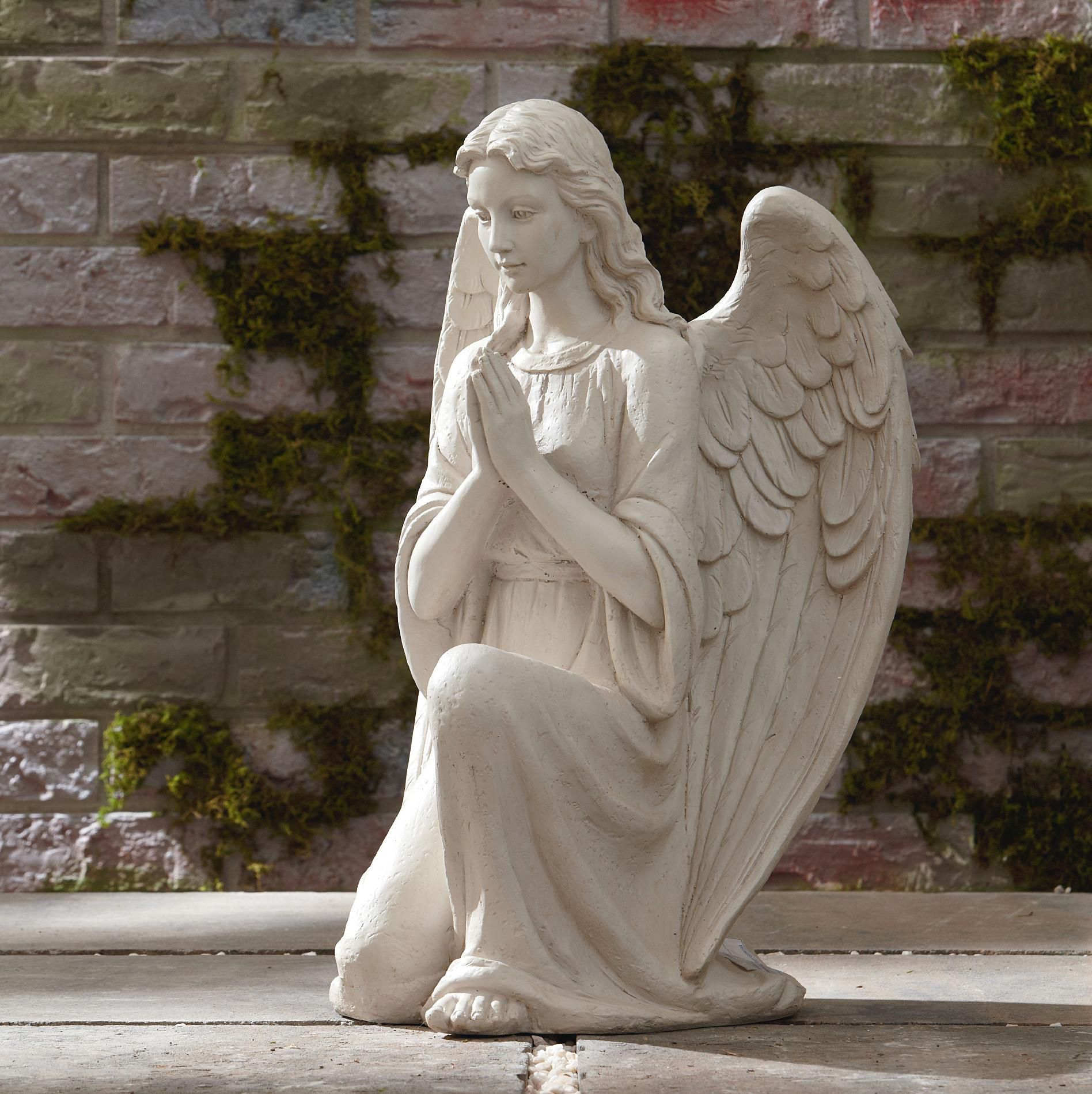 This little cherubic angel statue is sitting with hands over one ...