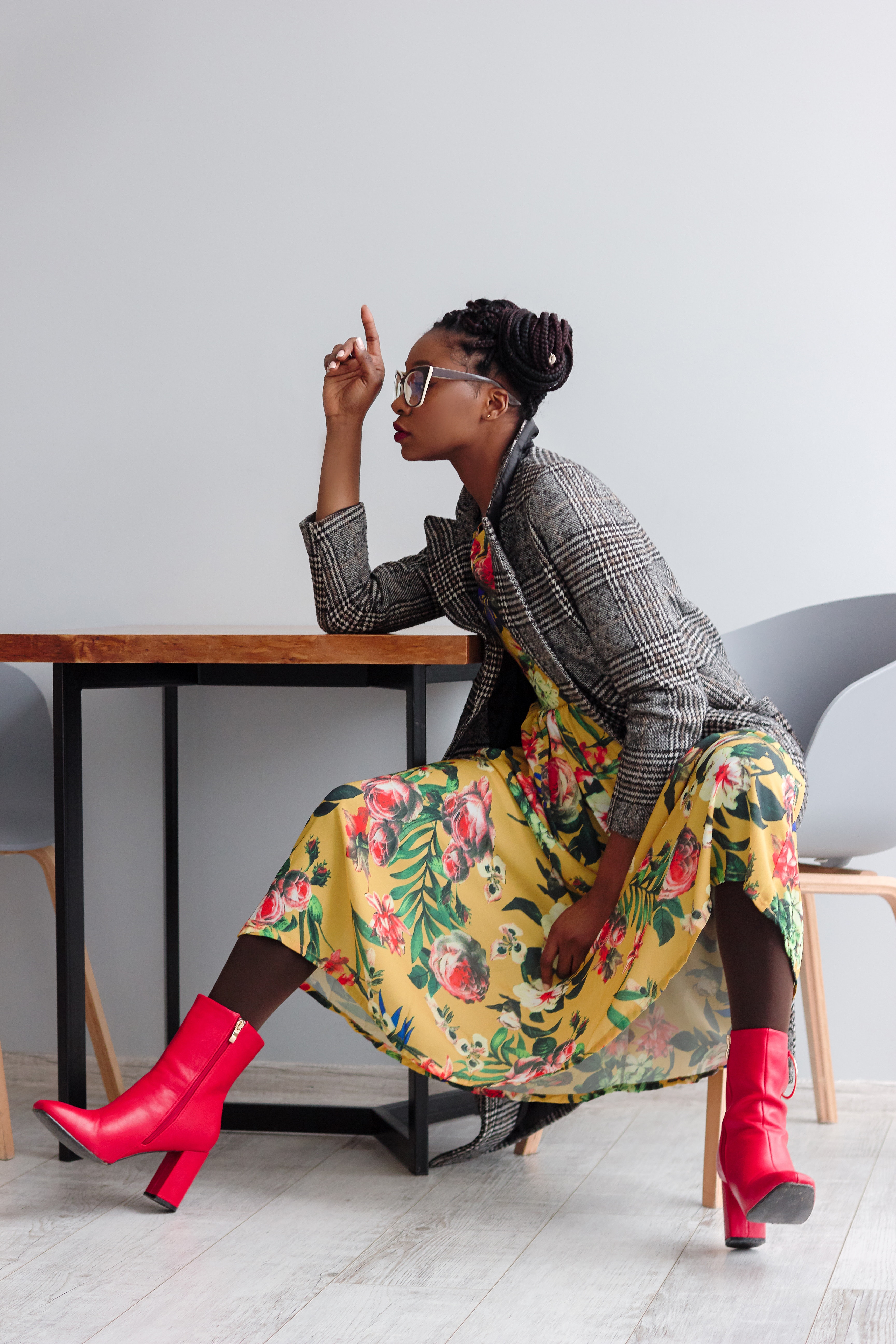 Woman sitting on a chair with open legs and right hand on top of wooden table photo