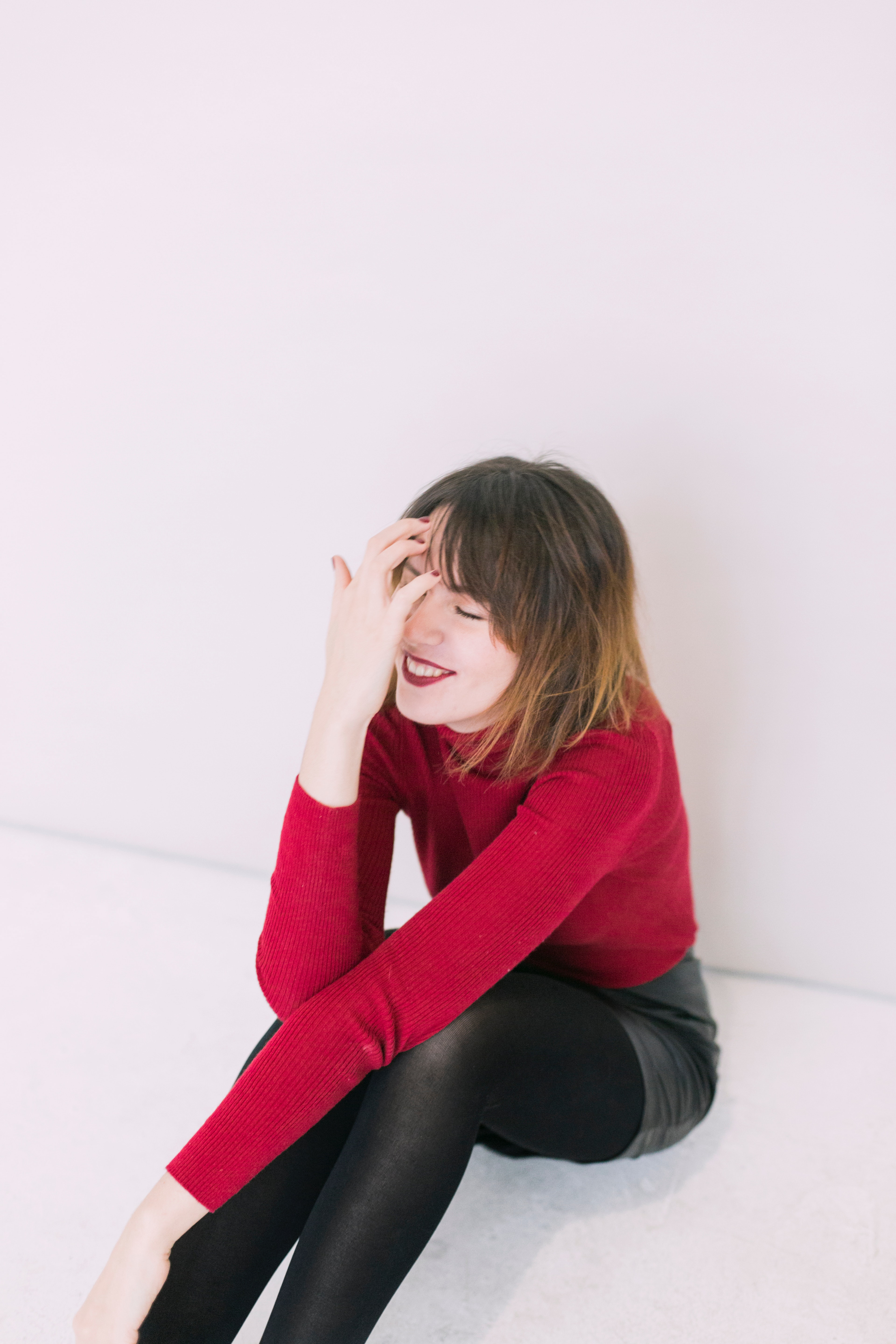 Woman sitting on the floor with left on her knees and the right hand in her face photo