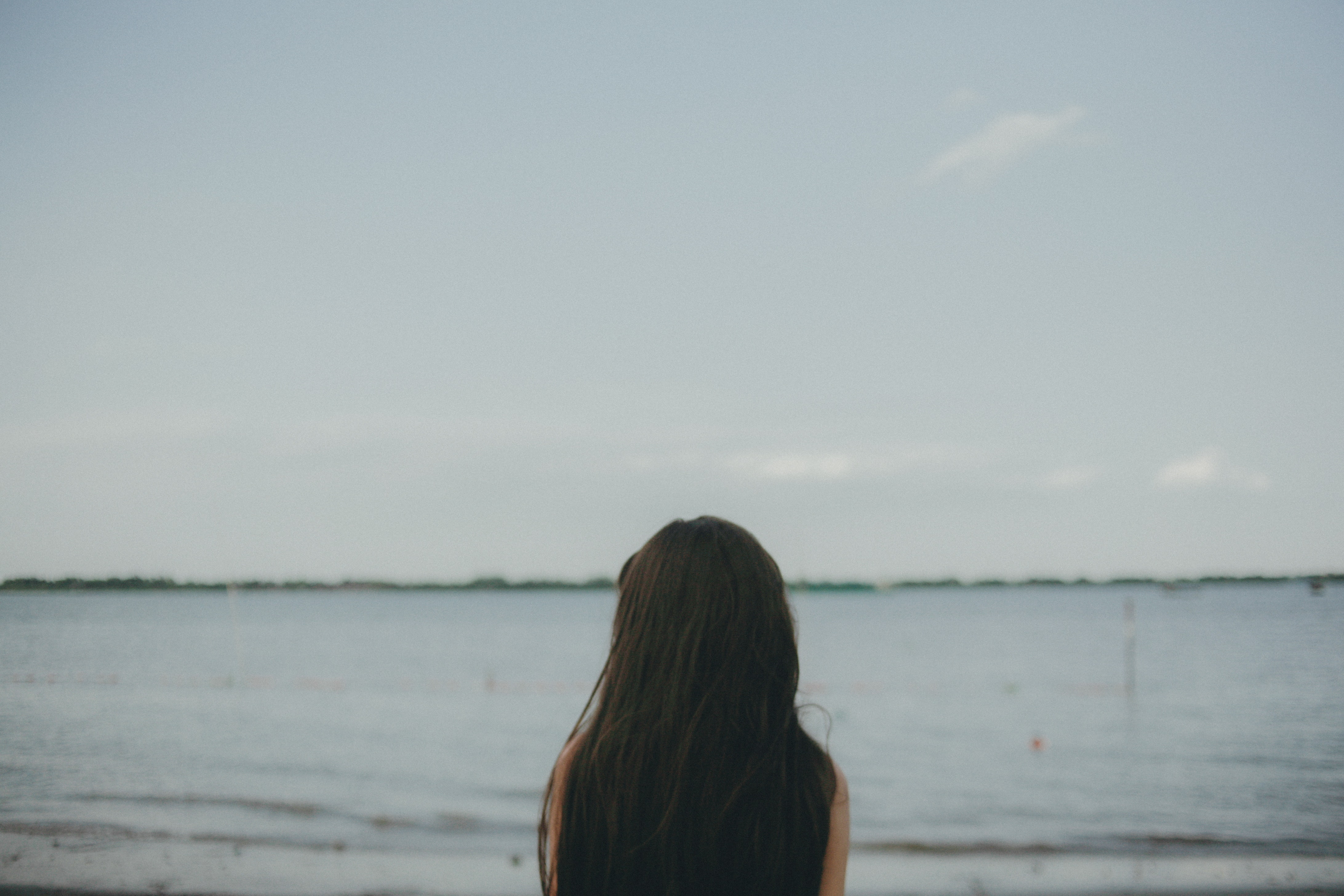 Woman standing near body of water during daytime photo