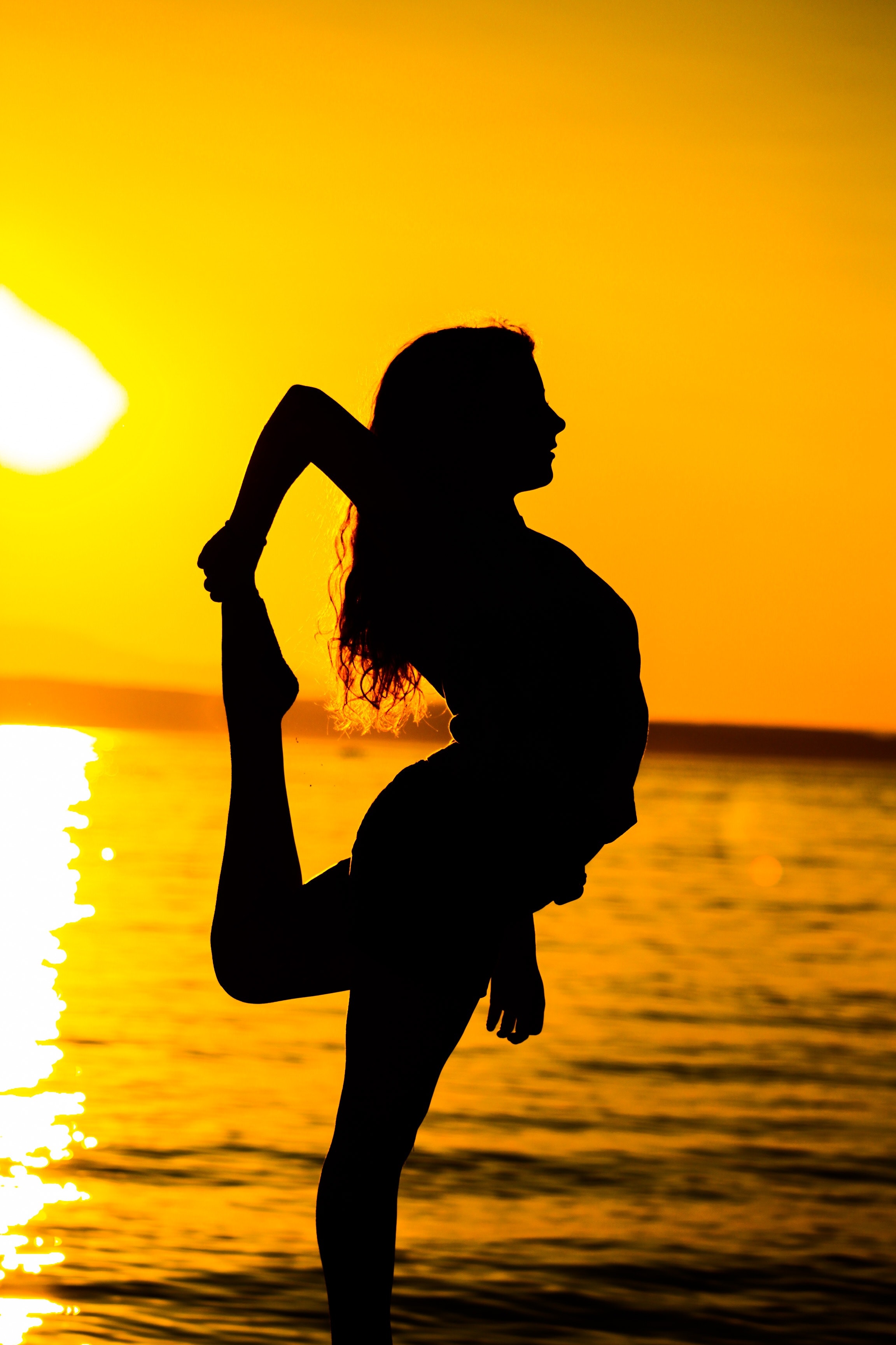 Woman standing on beach during sunset photo