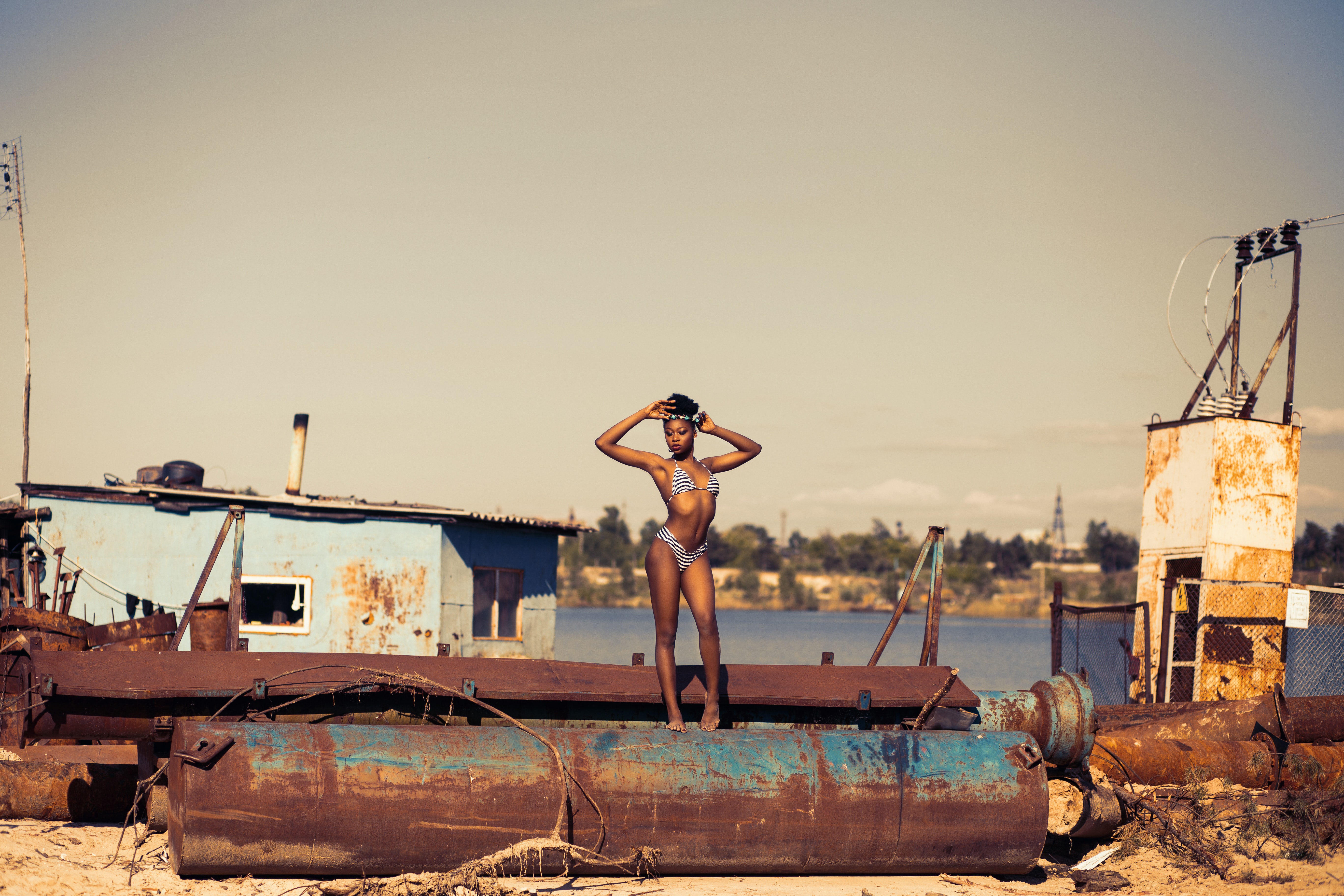 Woman standing on brown steel container wearing two-piece bikini photo