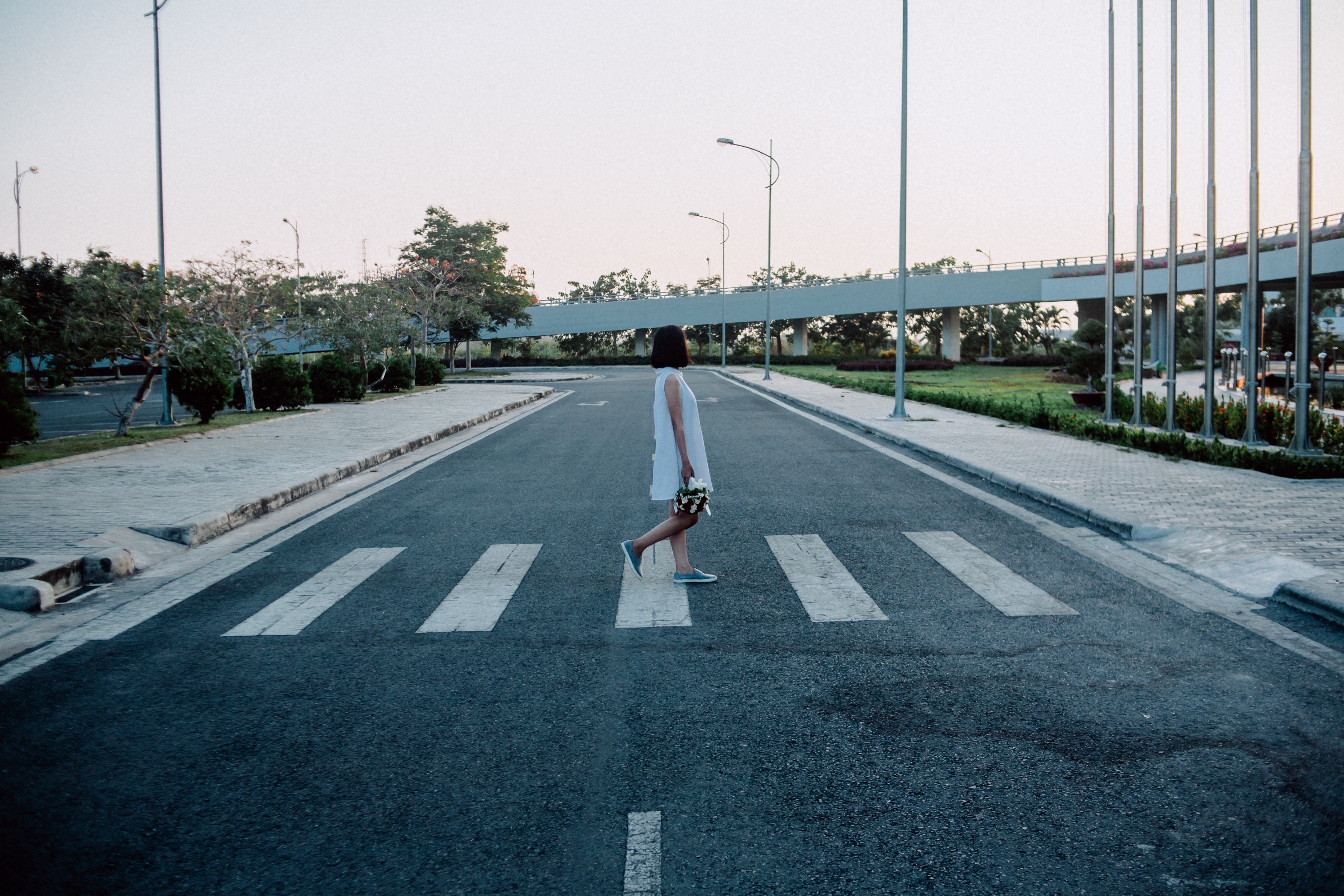 Woman standing on gray and white road crosswalk photo