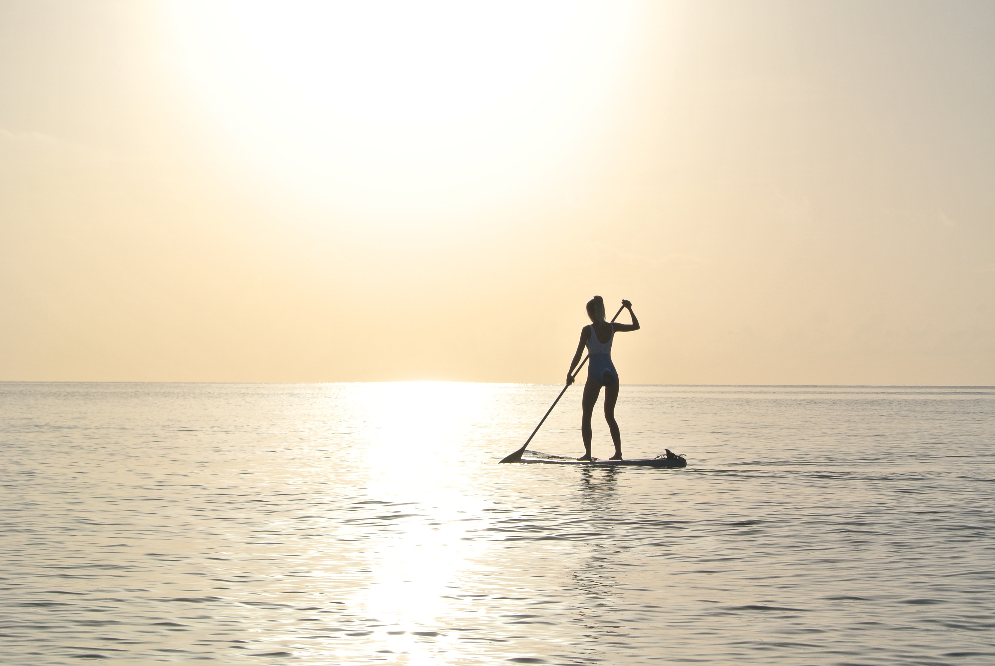 Woman standing on paddleboard on body of water photo