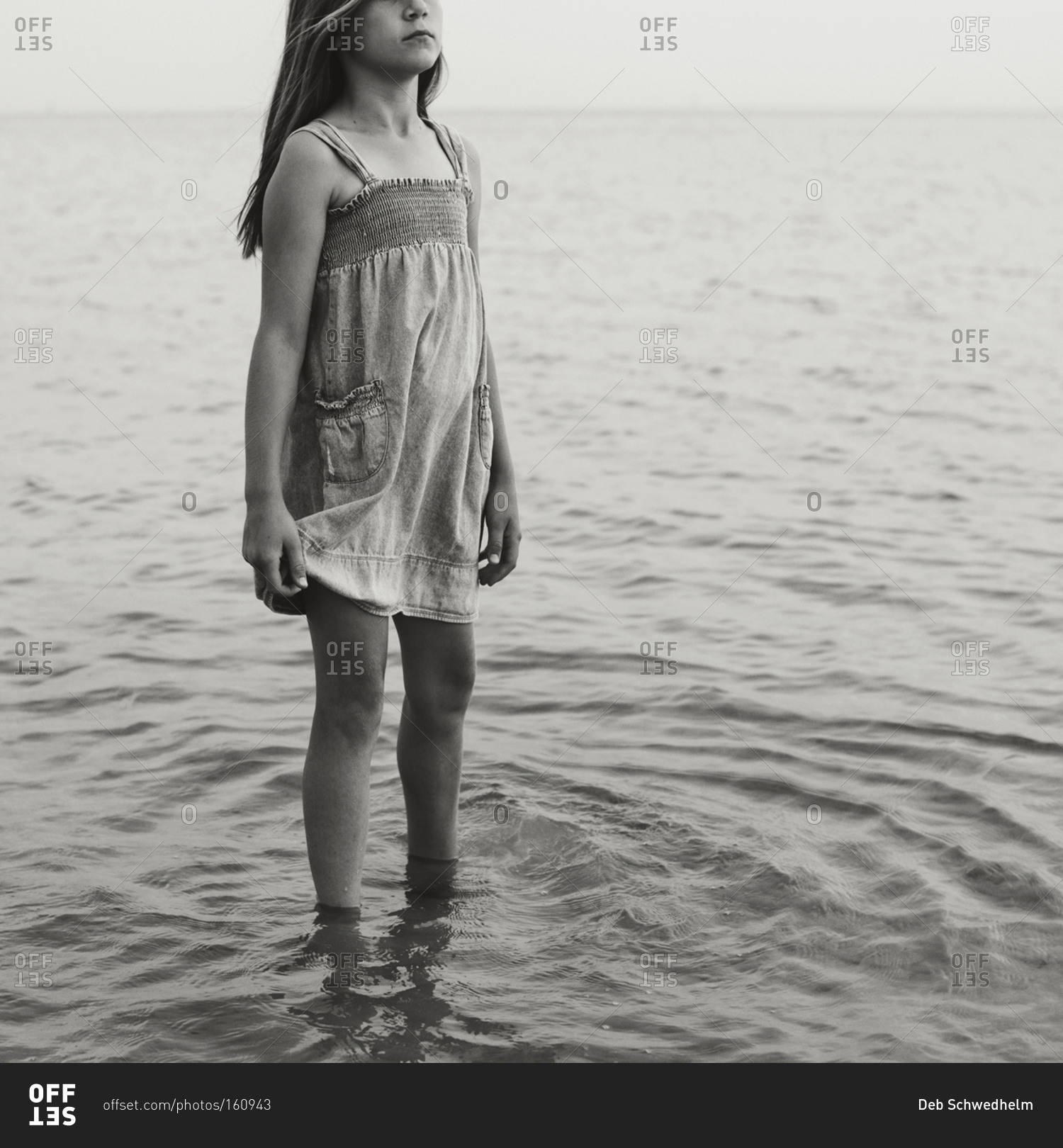 Girl standing in shallow water stock photo - OFFSET
