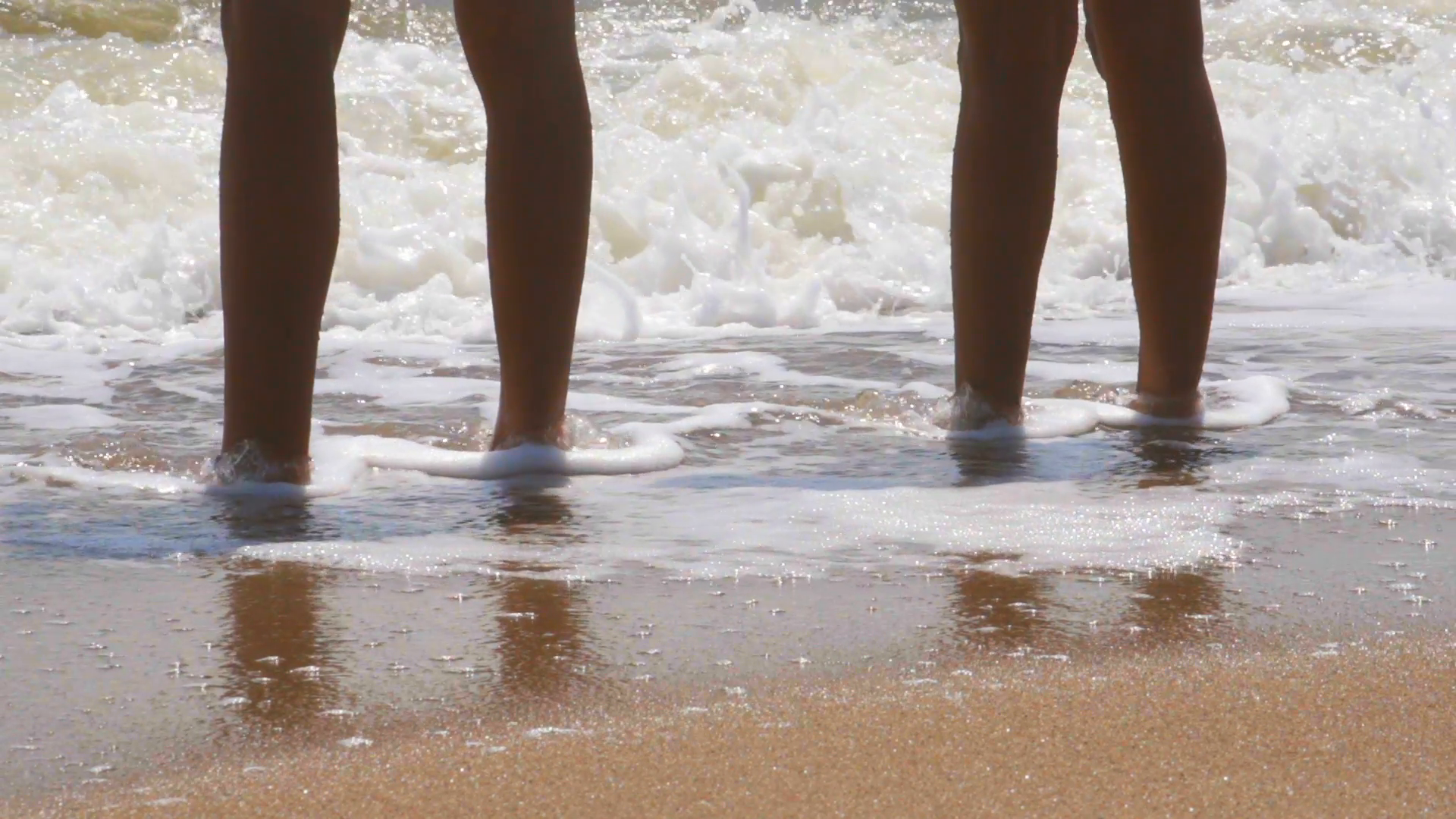 Man and woman standing in shallow surf Stock Video Footage - VideoBlocks