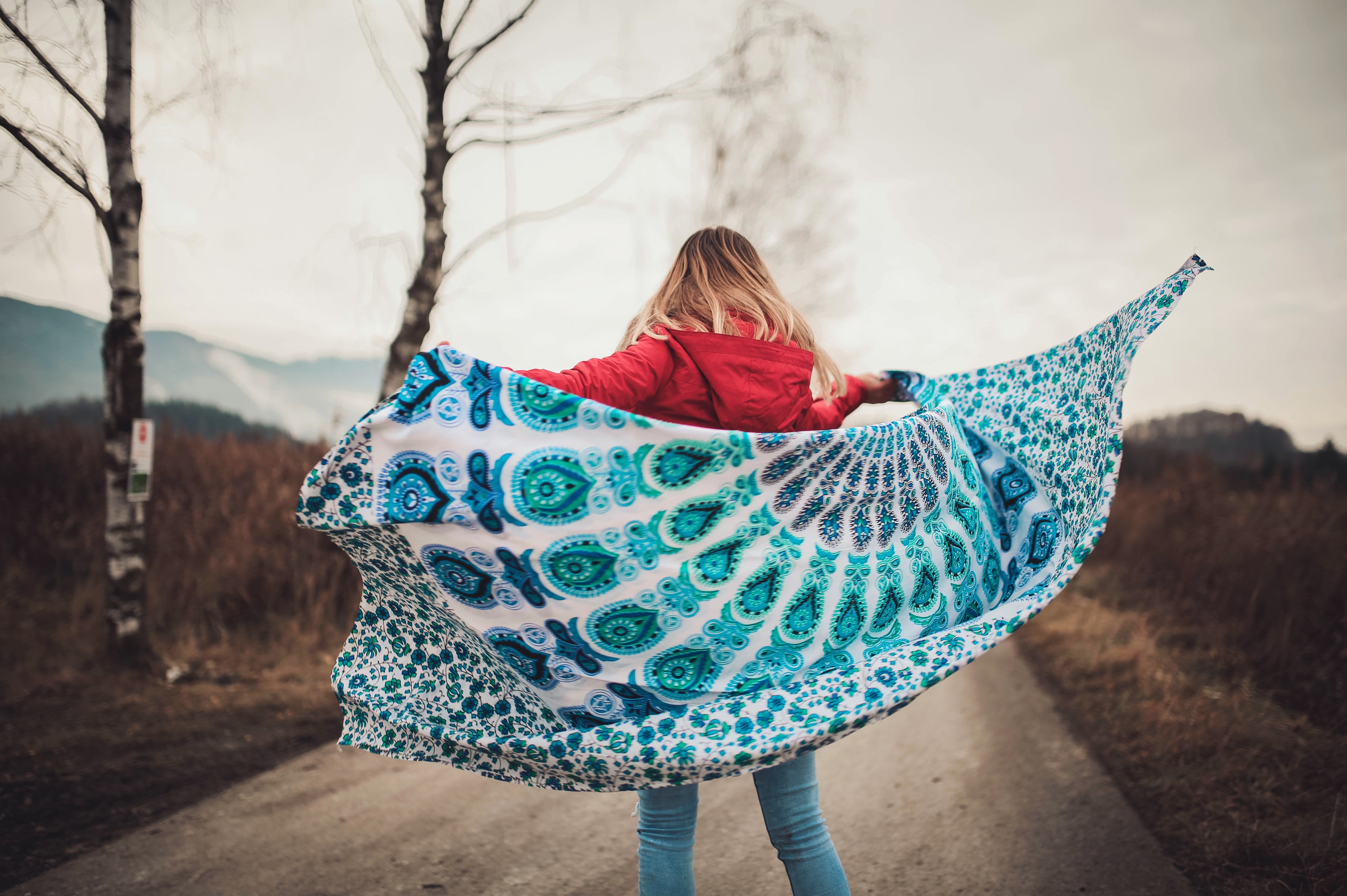 Woman standing on the middle of the road holding blanket photo