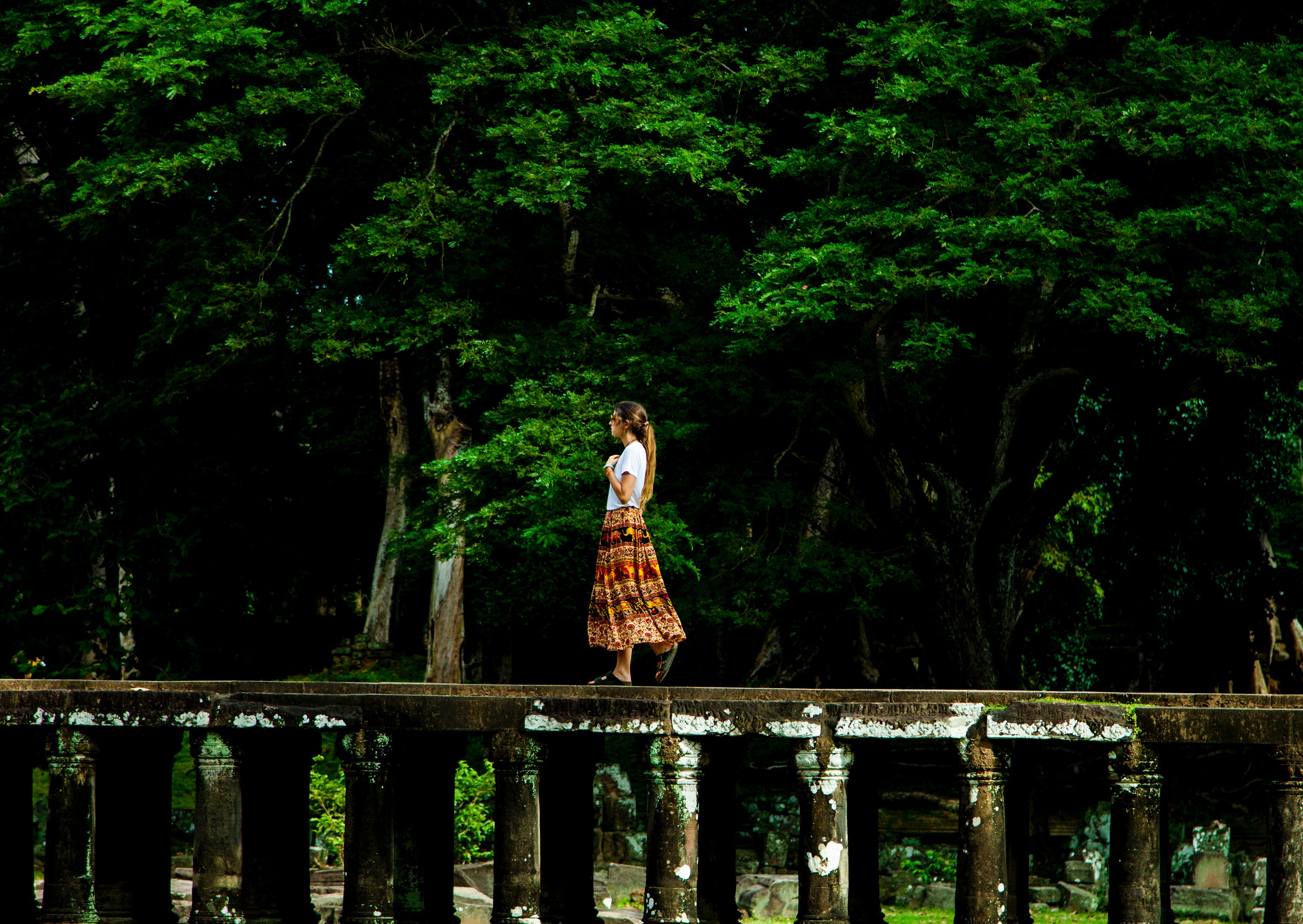 Woman walking on bridge surrounded by trees photo
