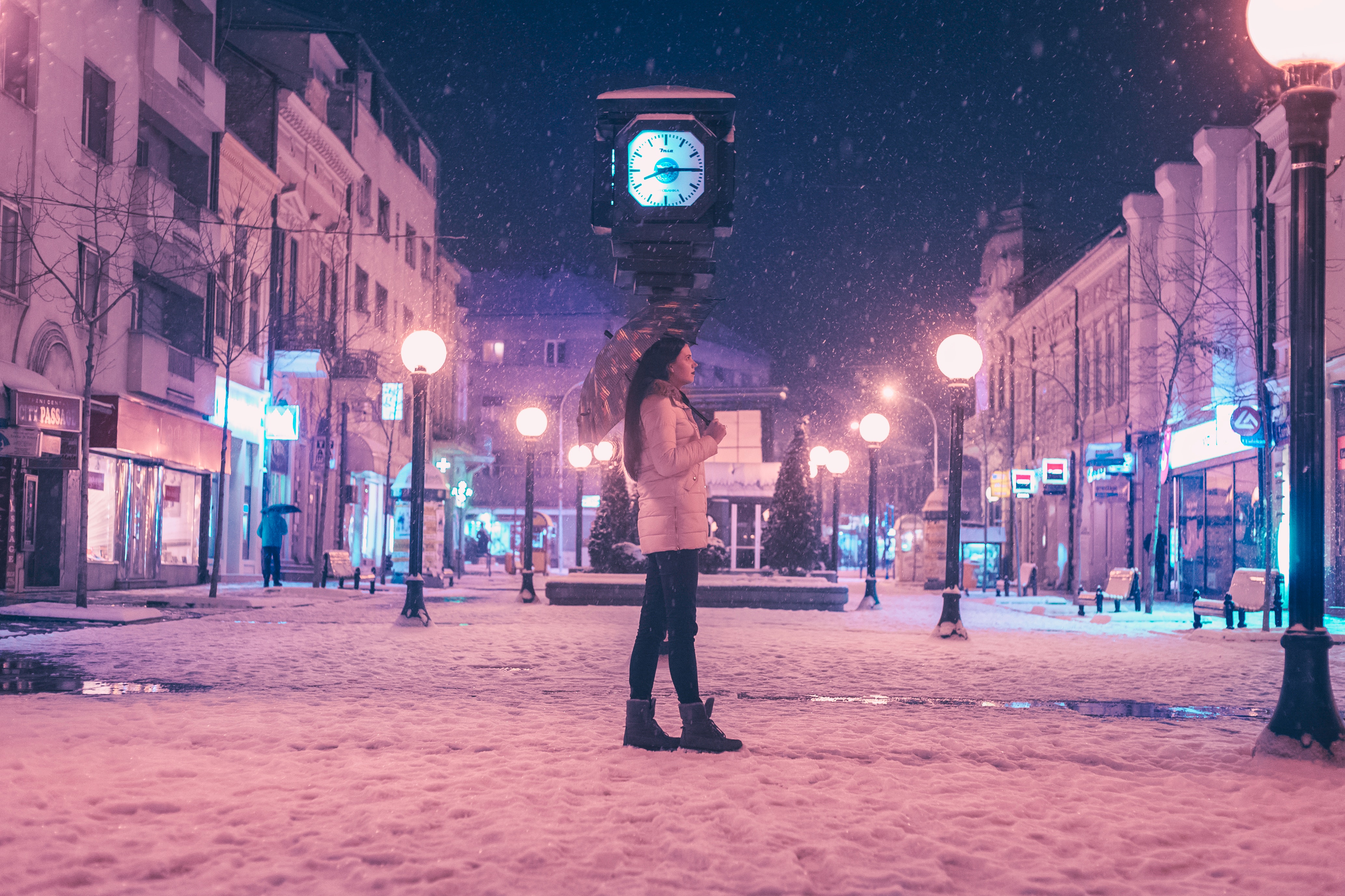 Woman walking on street near light post during winter season photo