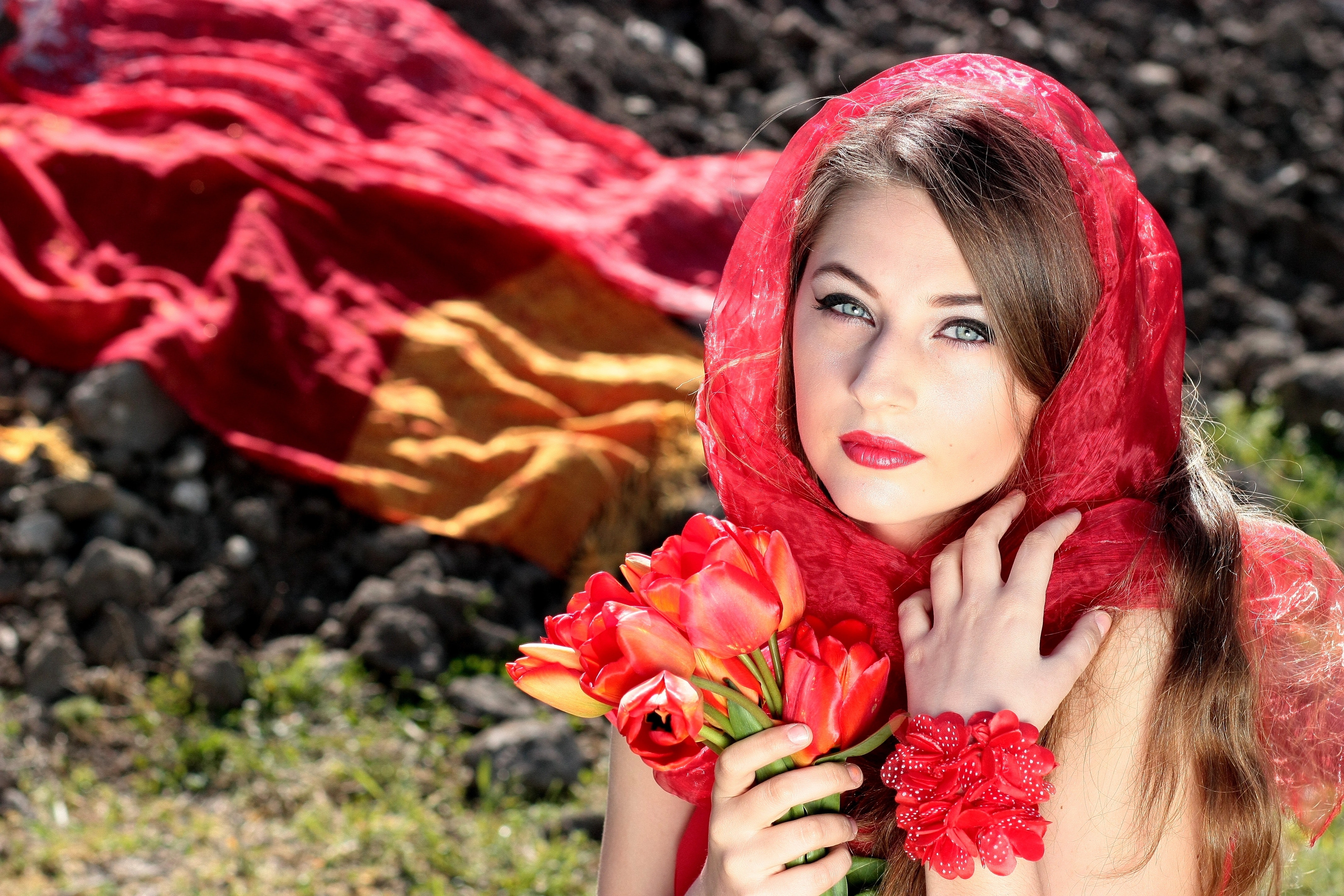 Woman wearing a red scarf holding red flowers photo