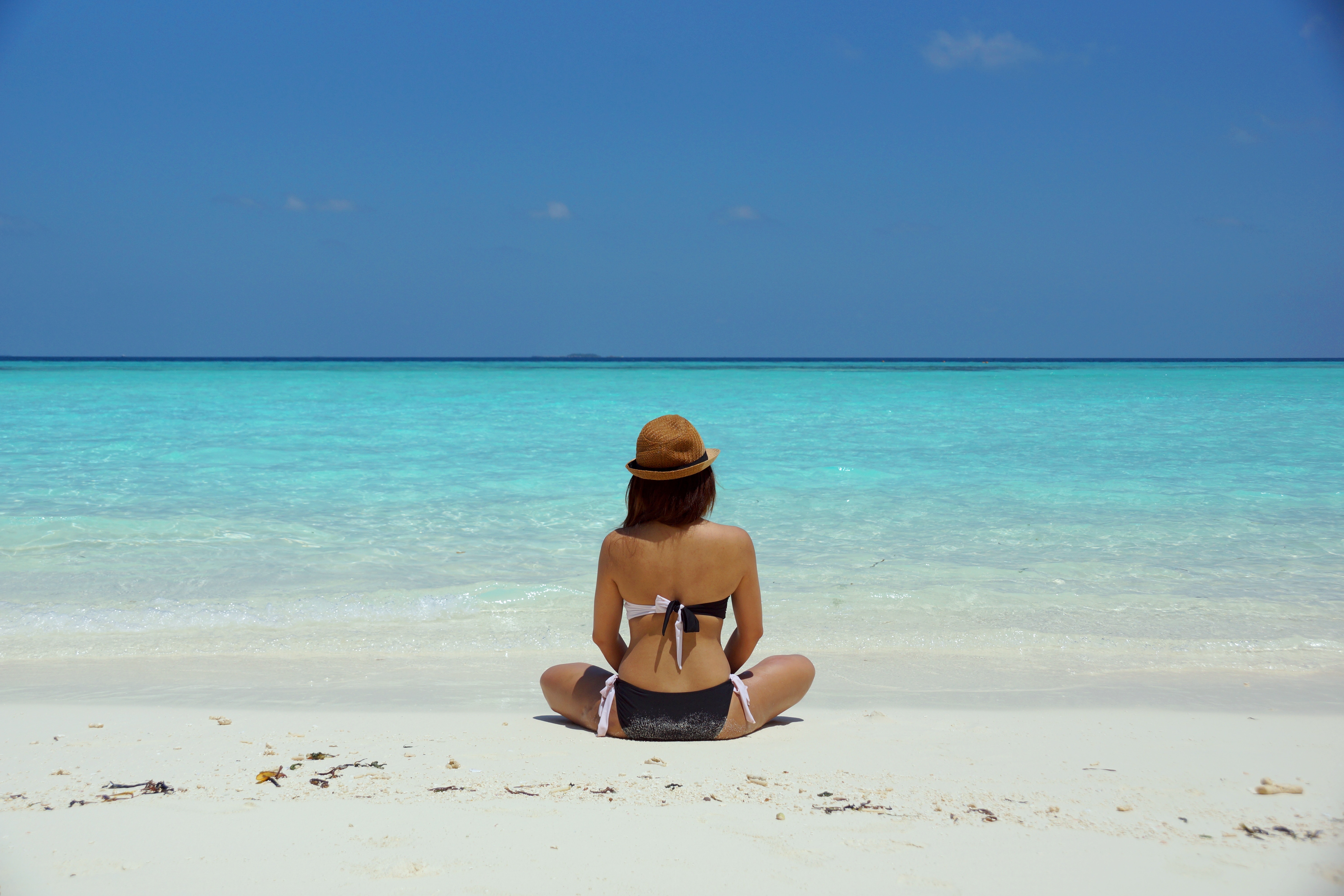 Woman wearing black and white brassiere sitting on white sand photo