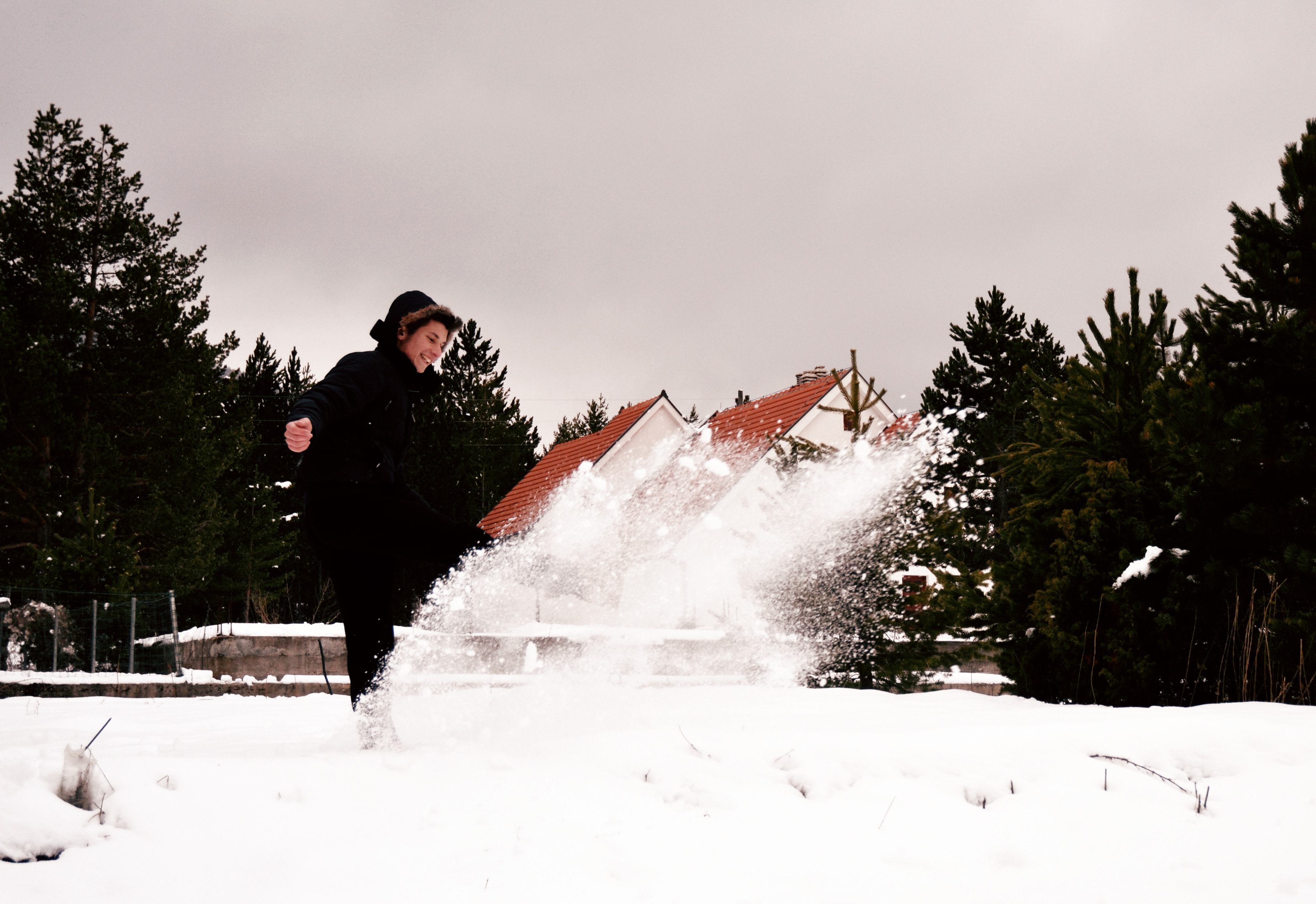 Woman wearing black coat while playing with snow photo