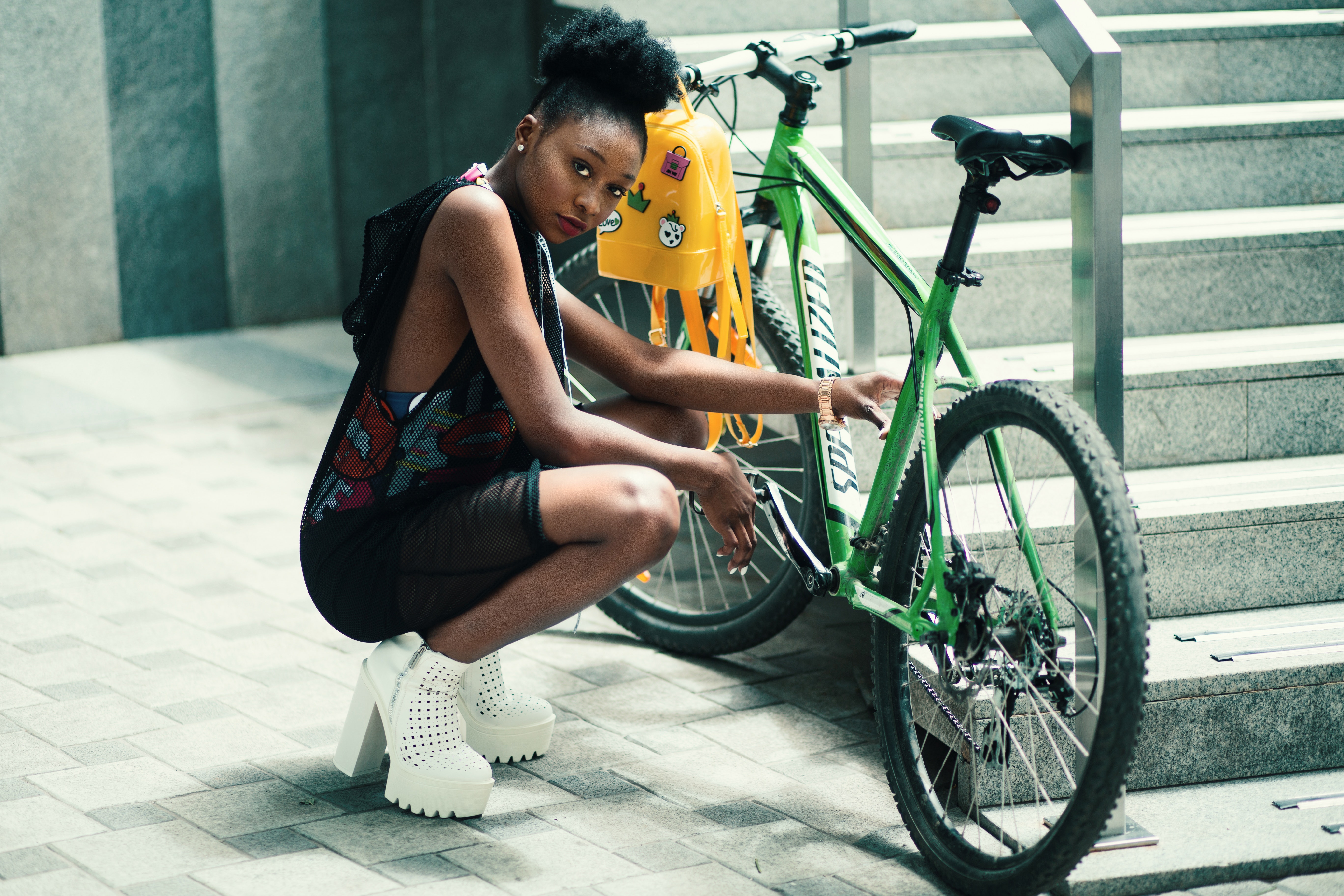 Woman wearing black dress seating near green bicycle photo