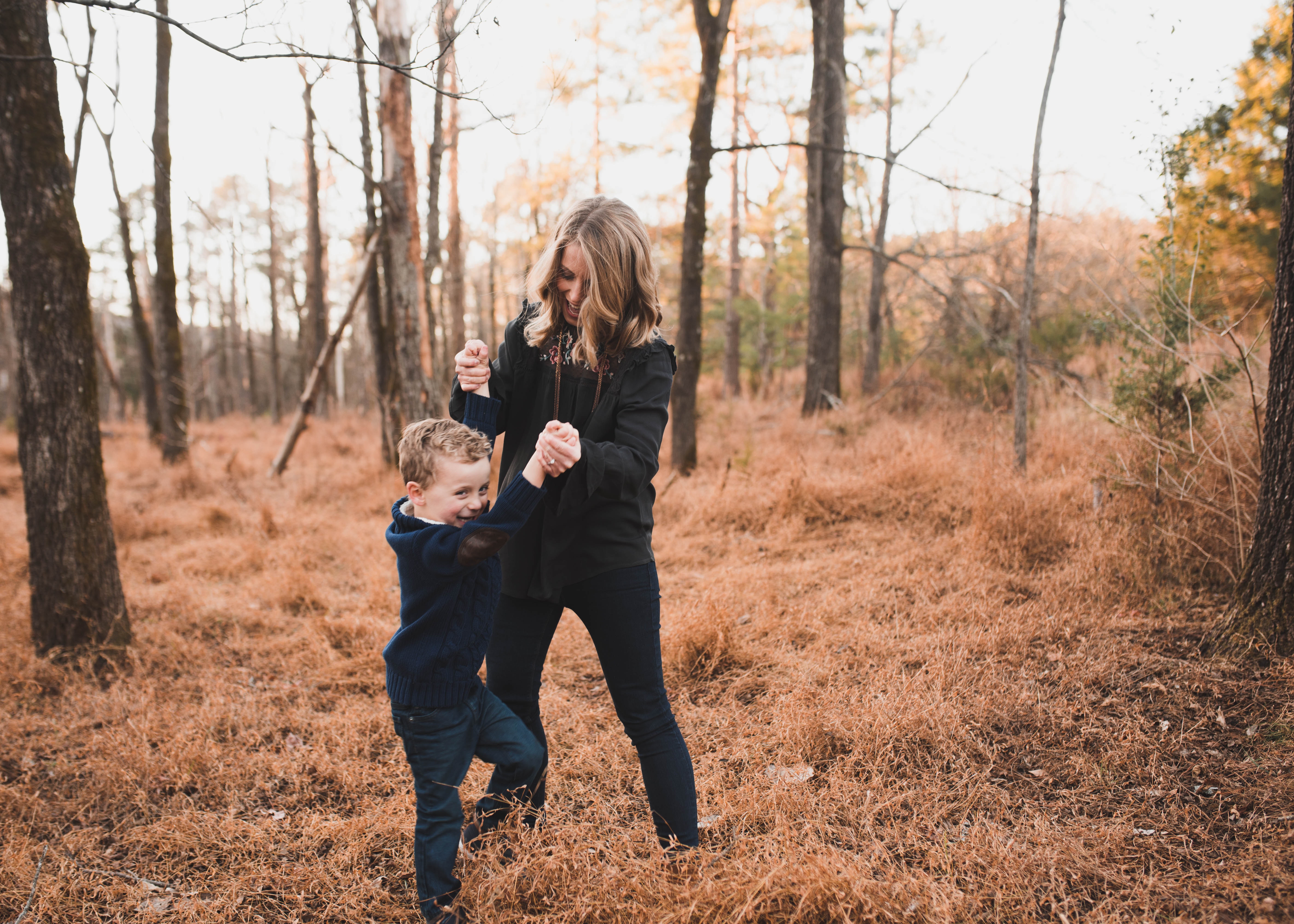 Woman wearing black jacket playing with young boy photo