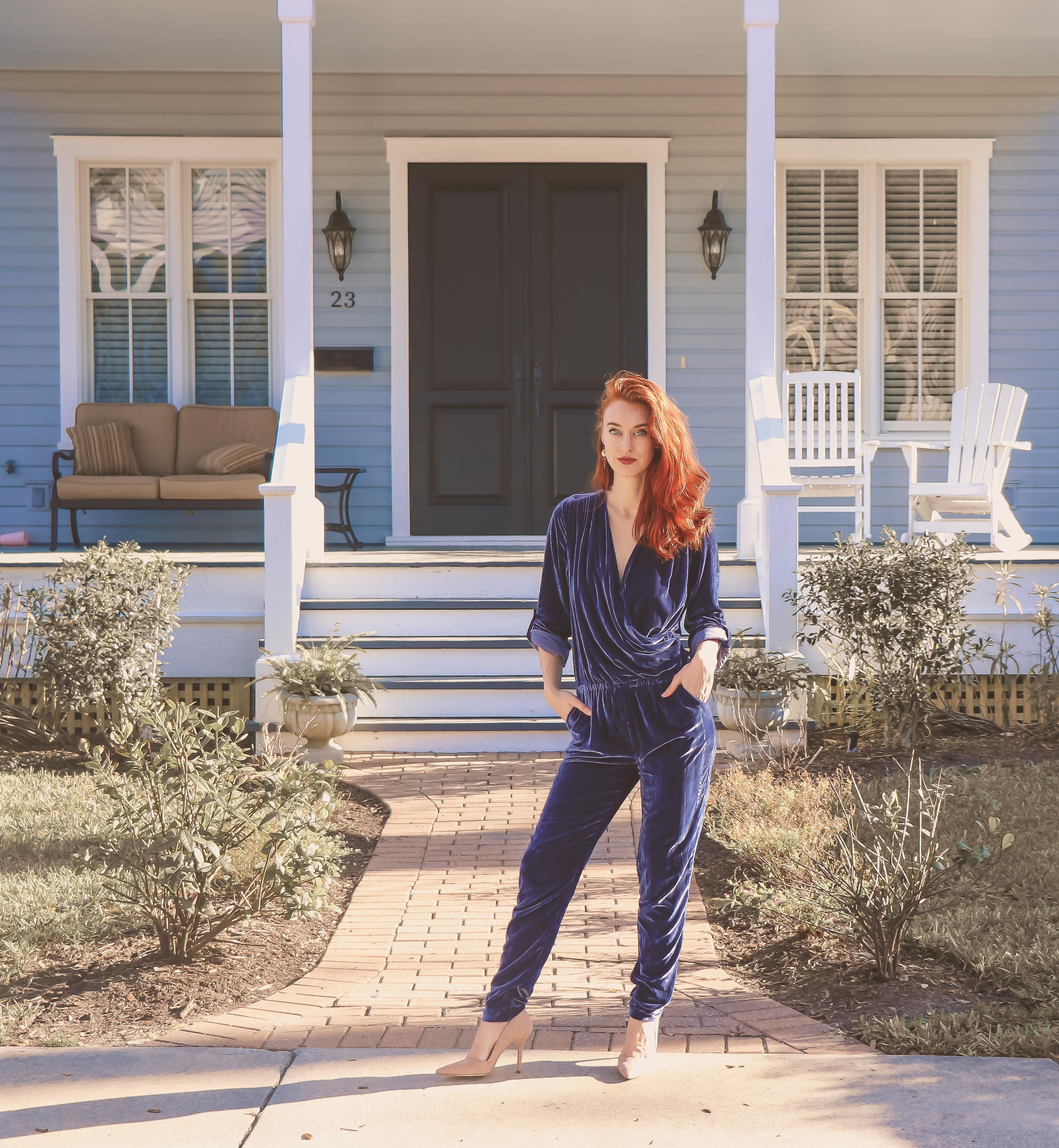 Woman wearing black jumpsuit standing near the house photo