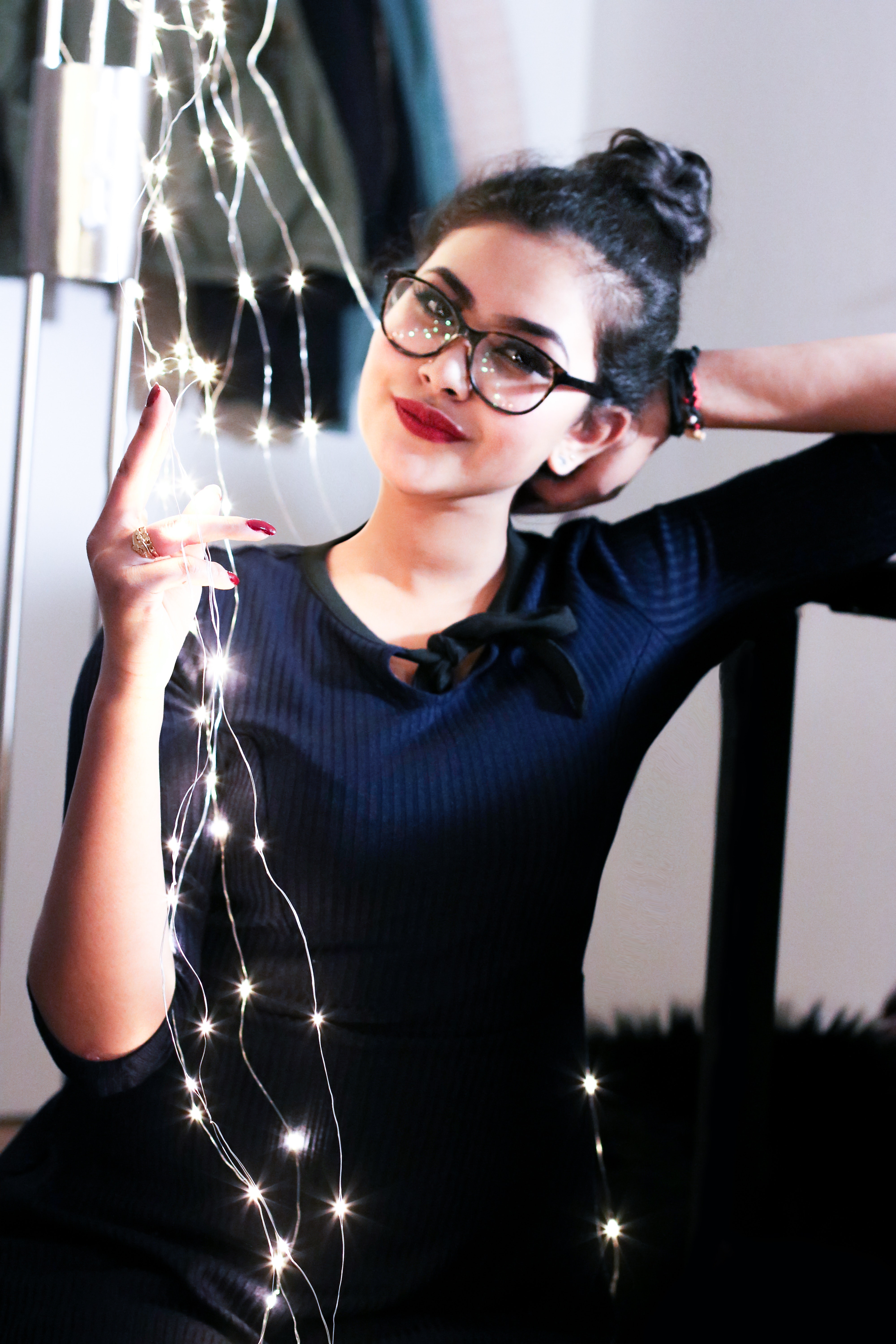Woman wearing black knit elbow-sleeved top touching mini string lights photo