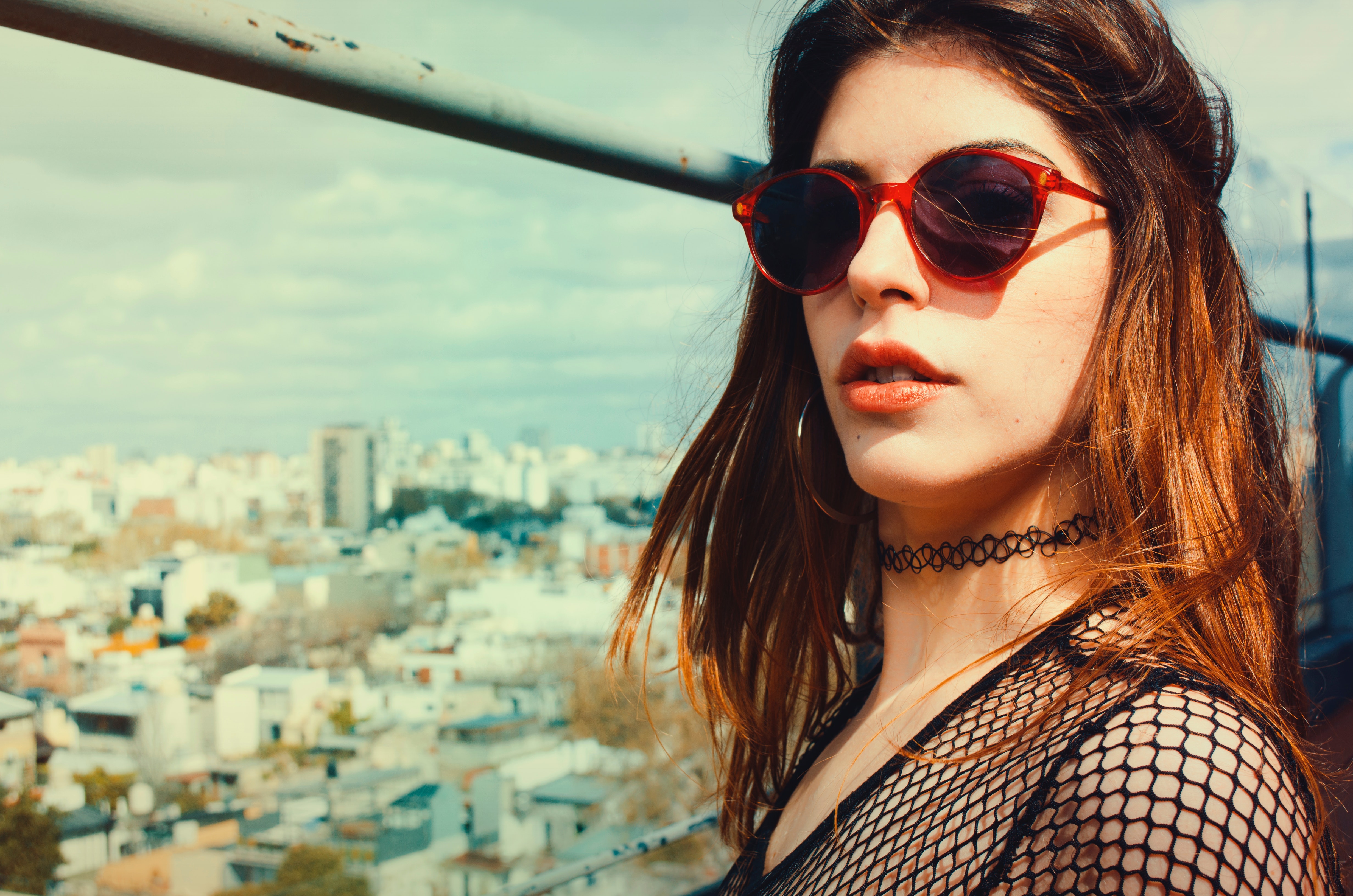 Woman wearing black lace scoop neck top and red framed black lens sunglasses photo